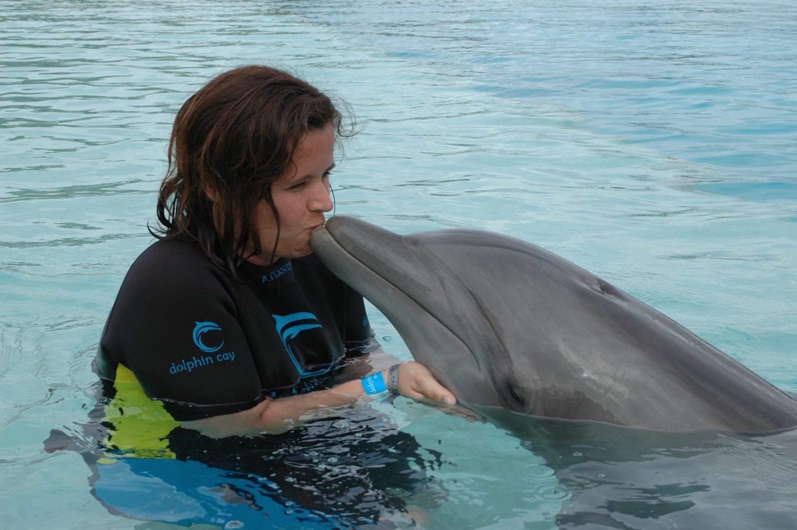Kathy kissing the dolphin at Dolphin Cay