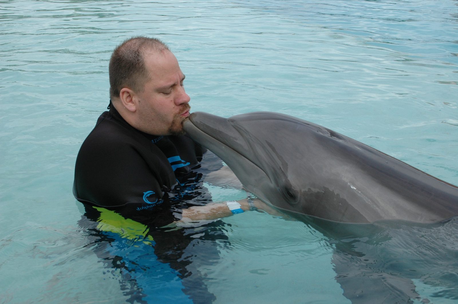 Michael kissing the dolphin at Dolphin Cay