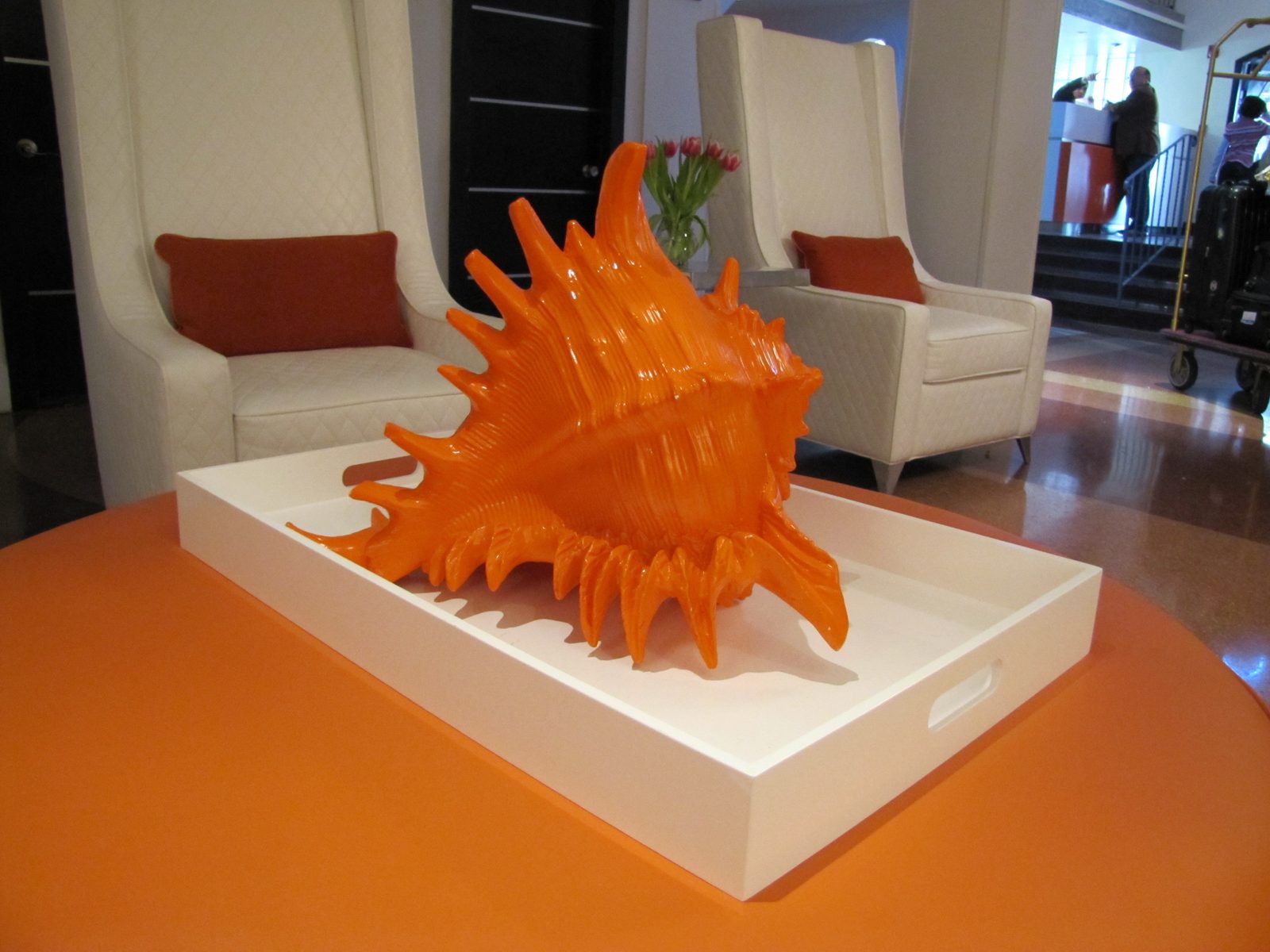 An orange conch shell sculpture in a hotel lobby
