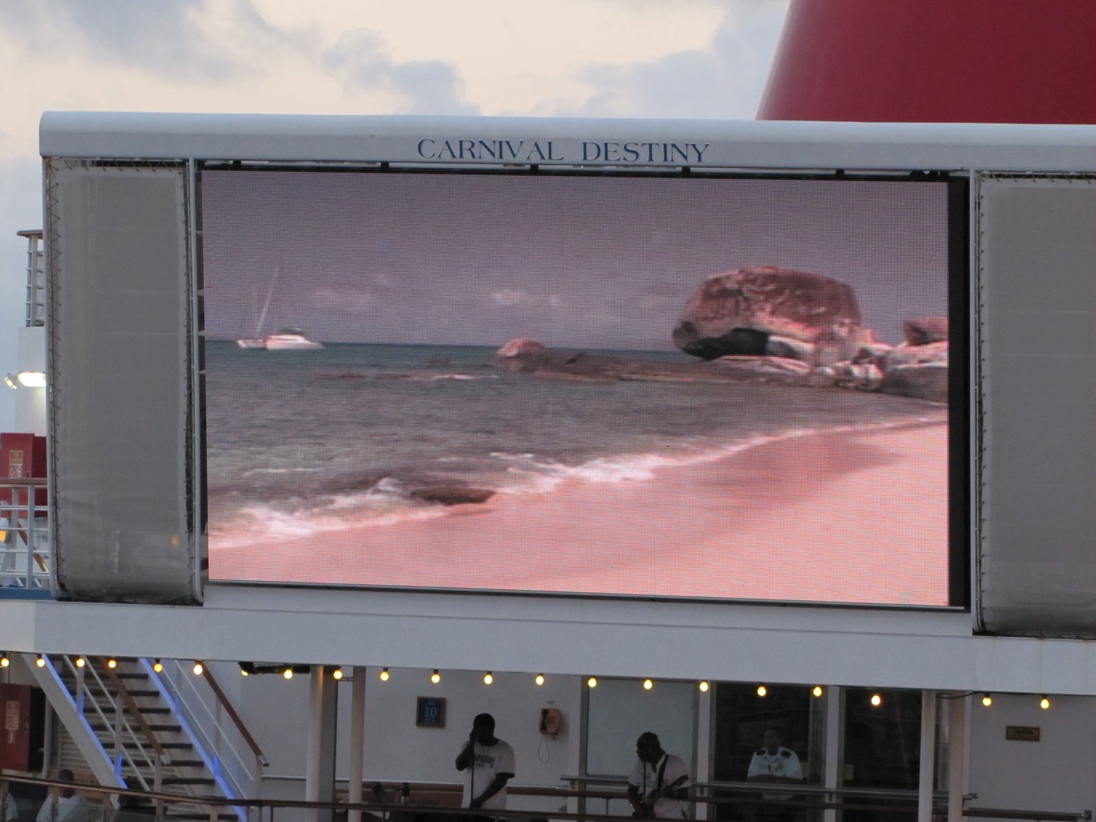 A movie playing on the pool deck screen