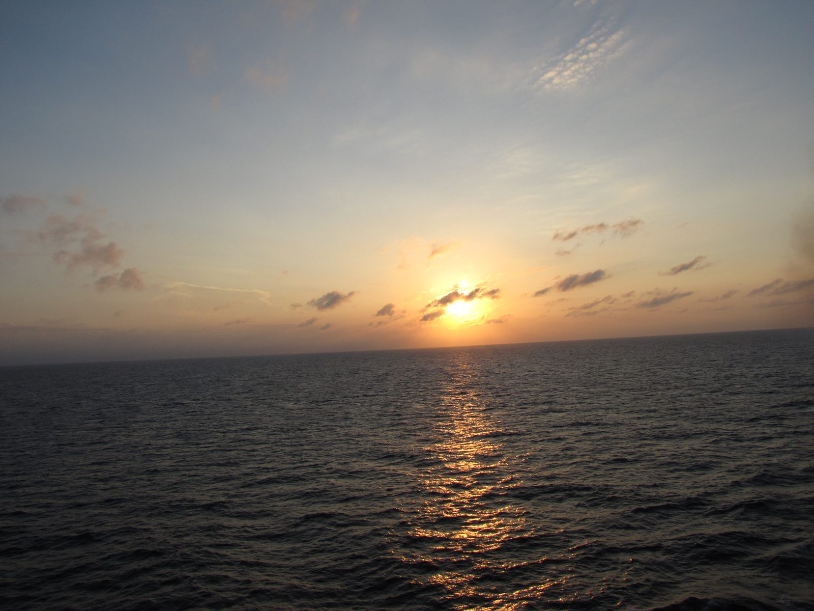 Sunset from the ship, the sun sinking over a calm Caribbean sea