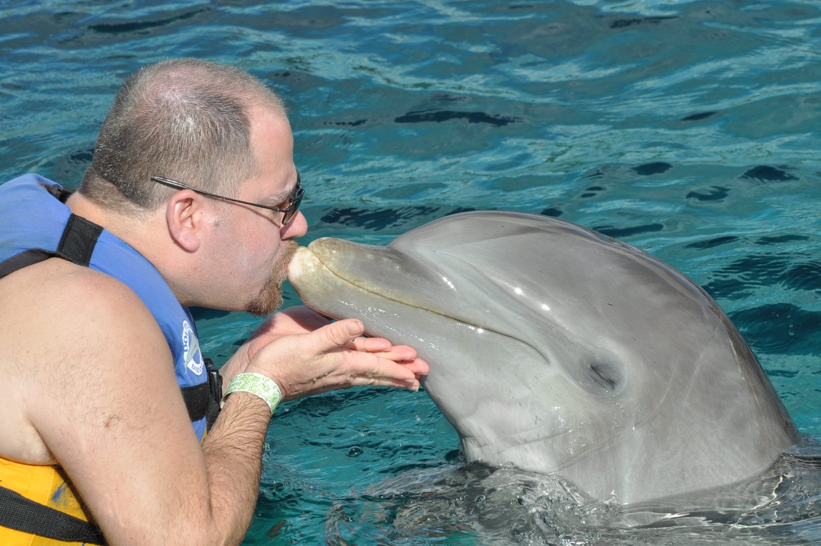 Michael kissing a dolphin at Chankanaab
