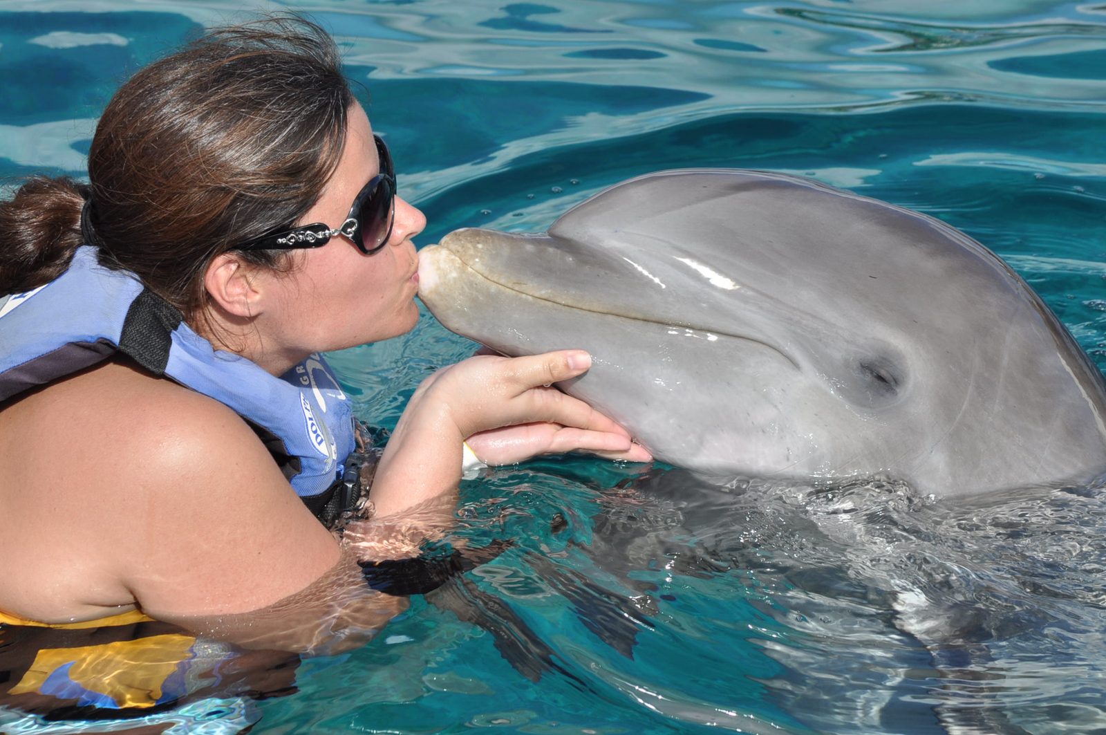 Kathy kissing a dolphin at Chankanaab