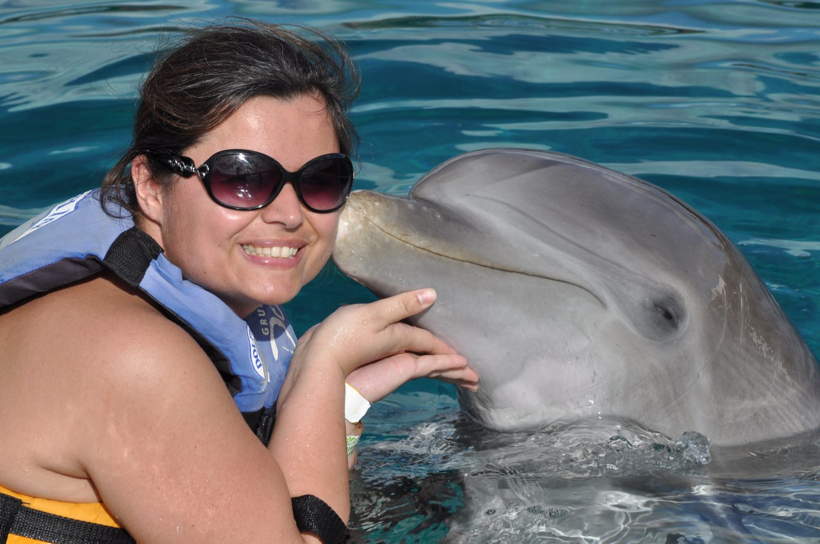 Kathy getting a kiss from a dolphin at Chankanaab