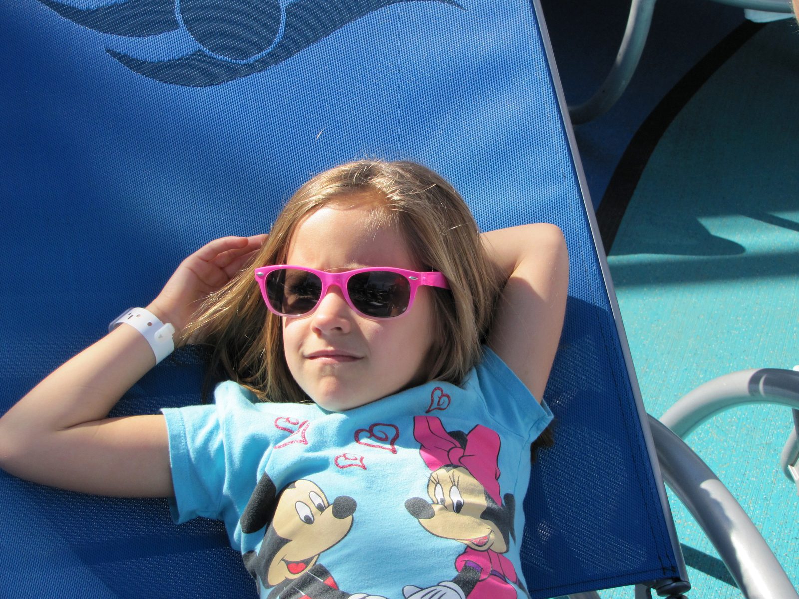 Lisa stretched out on the pool deck in her sunglasses