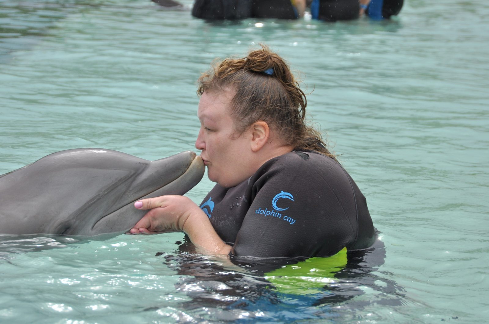 Kim getting a dolphin kiss at Dolphin Cay