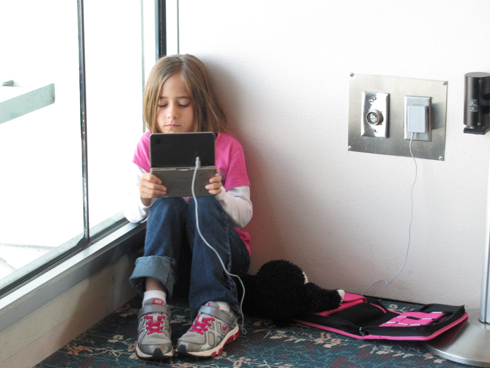 Lisa passing time on her handheld game at the airport