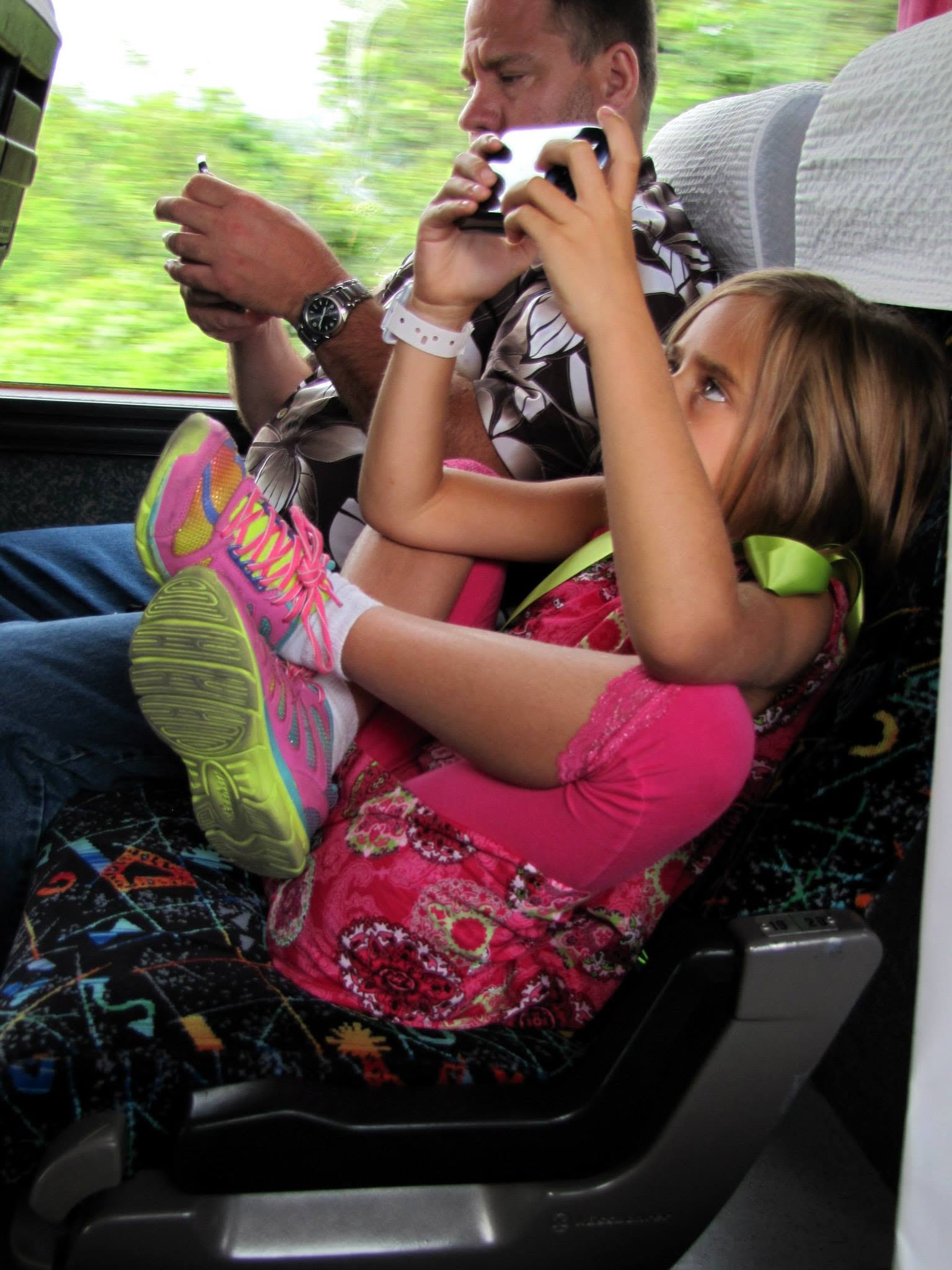 Lisa on her DS and Michael on his phone on the bus back