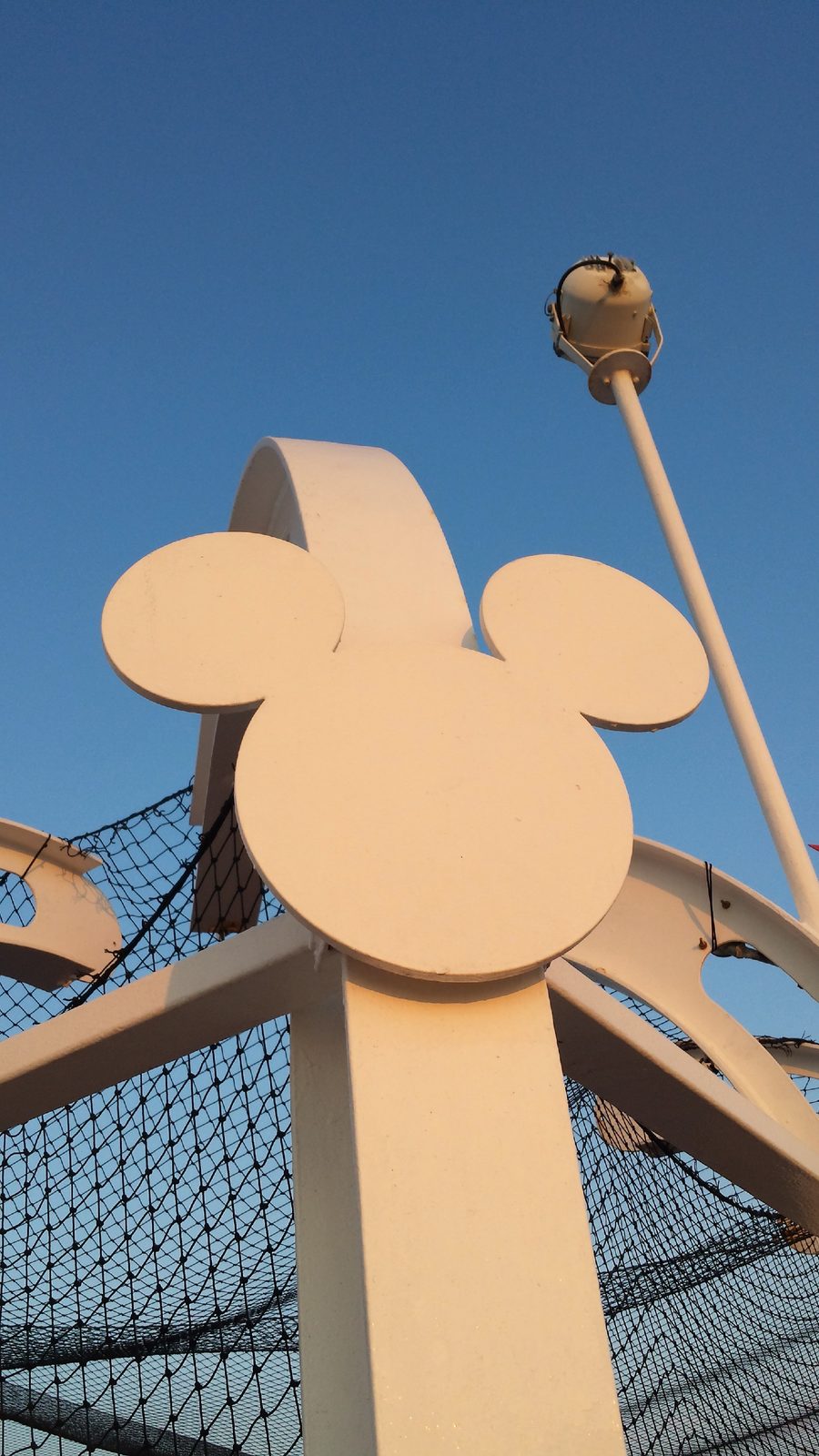 Mickey-shaped railing post against a blue sky