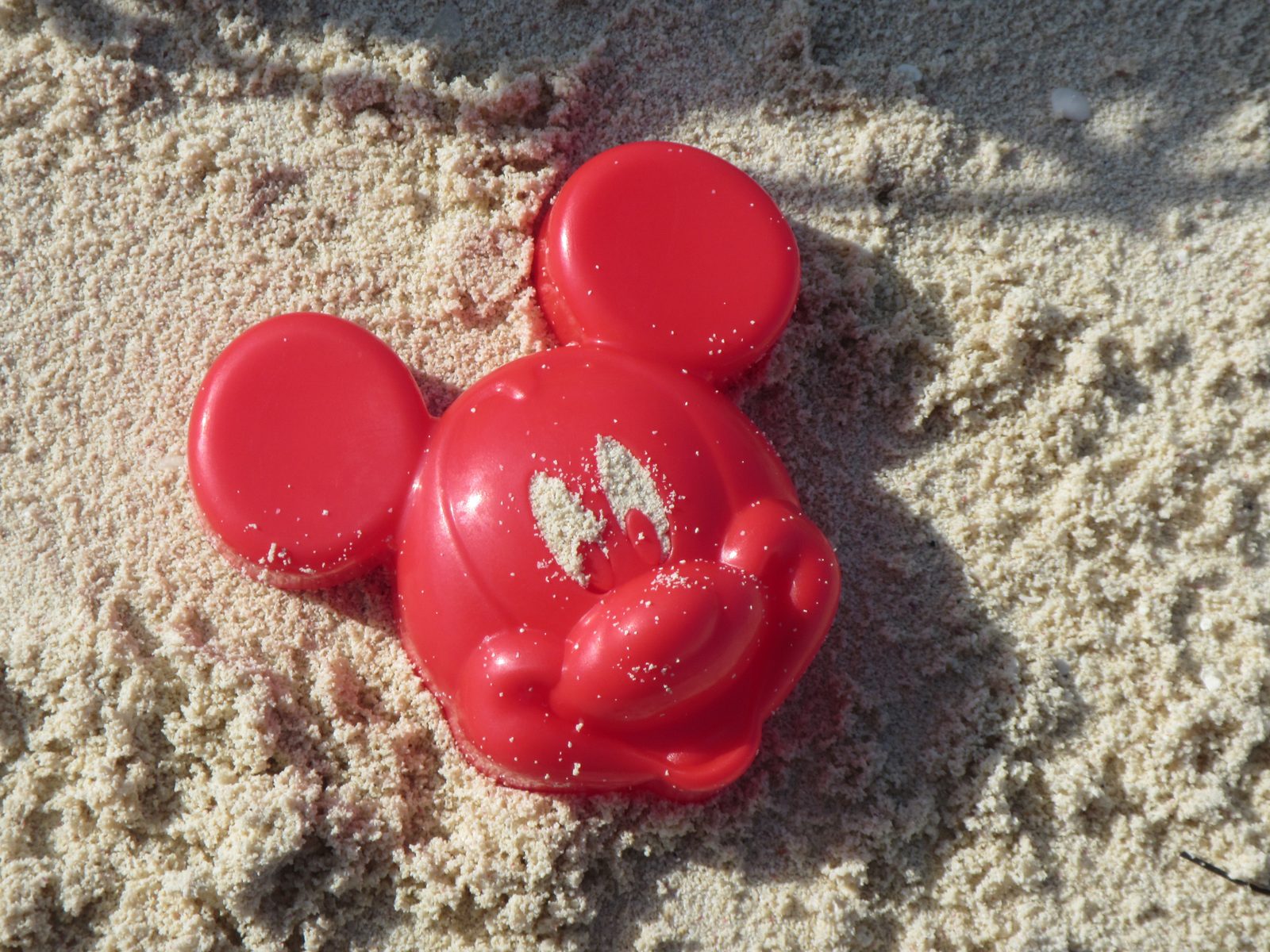 A Mickey-shaped mold pressed into the sand