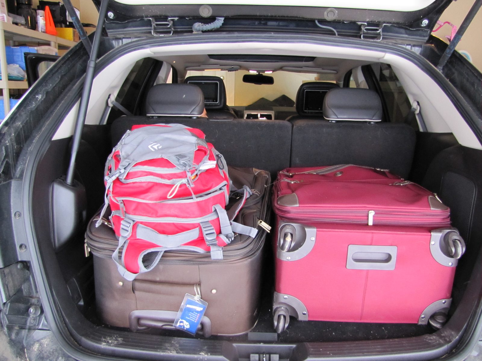 Suitcases packed into the car for the airport