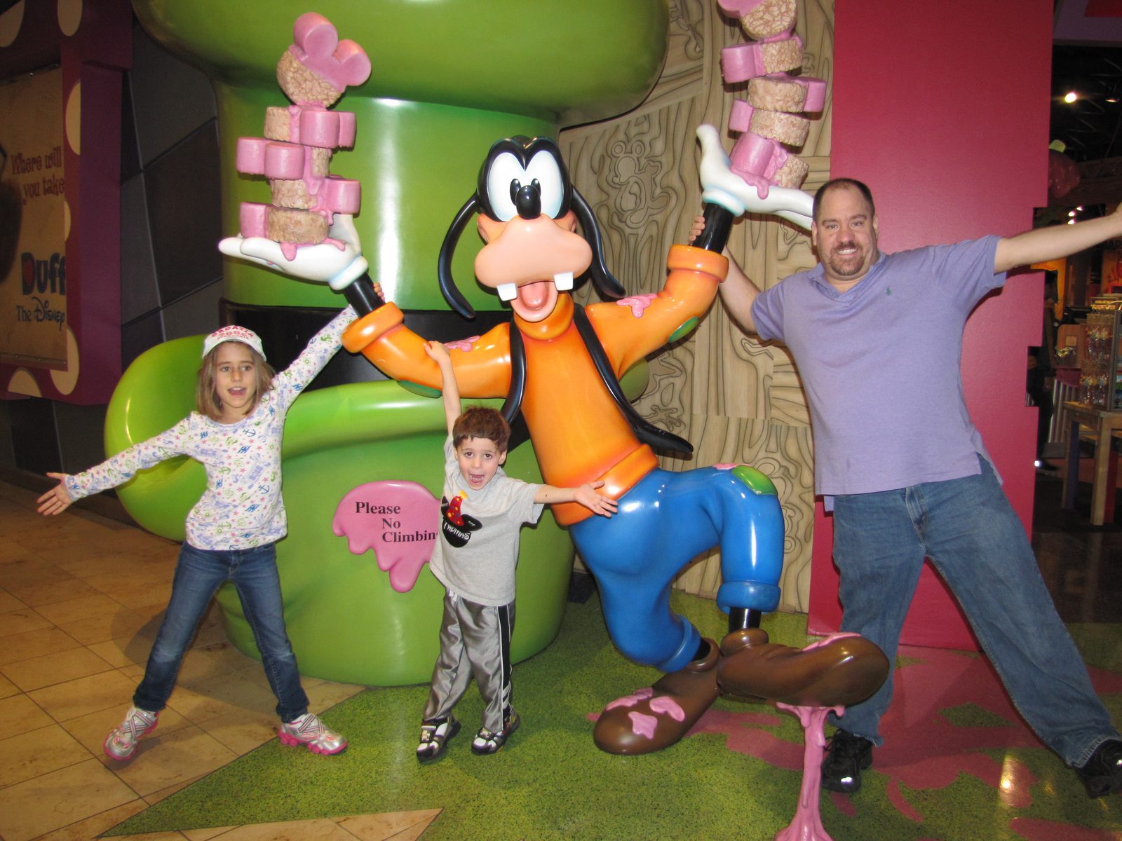 The kids and Michael with the Goofy statue at the Orlando airport