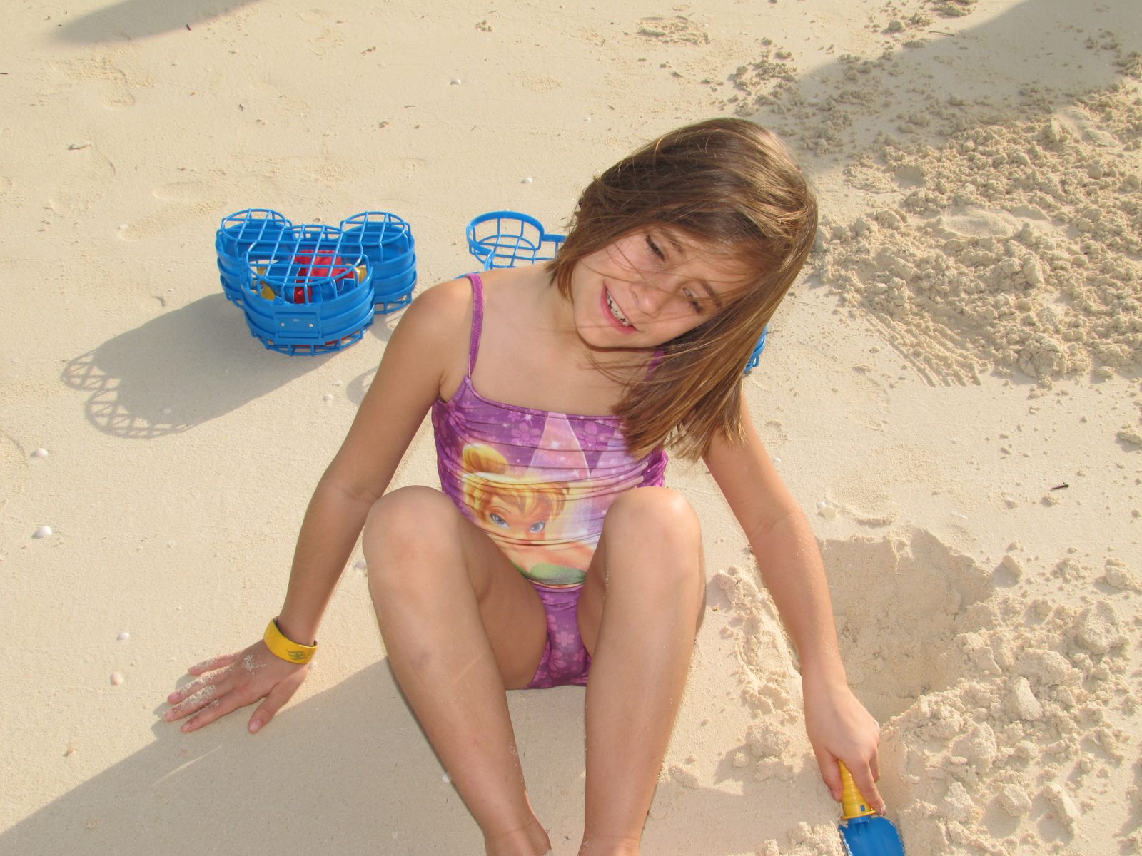 Lisa digging in the sand with a driftwood log