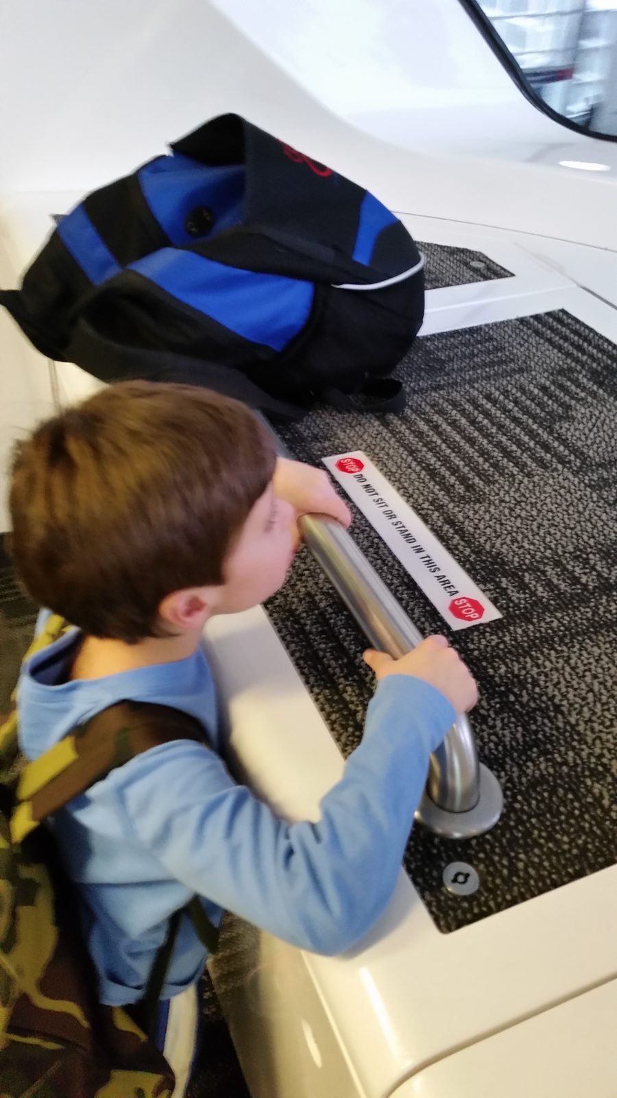 Thomas holds the rail on the airport tram