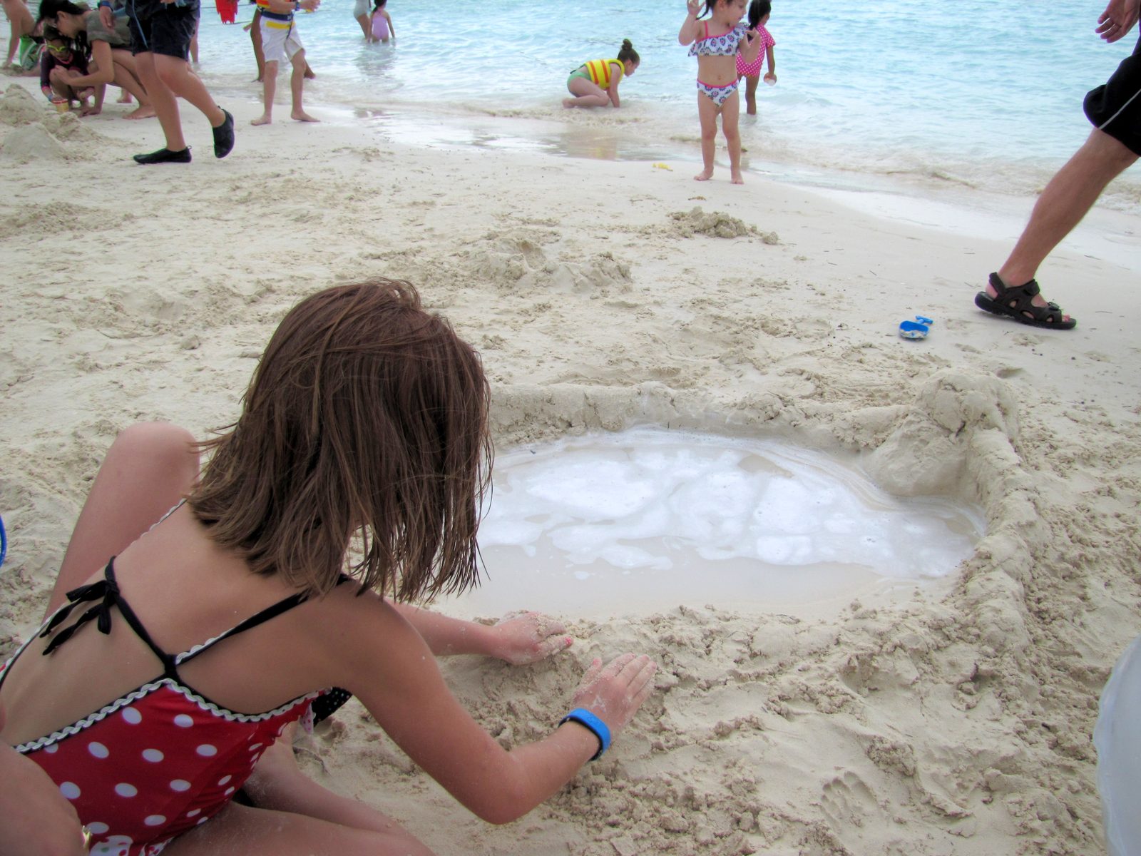 Lisa digs a moat for the sandcastle