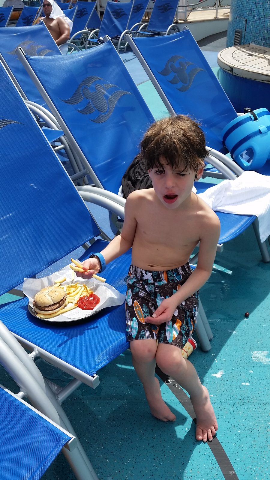 Thomas with a burger by the pool on the Wonder