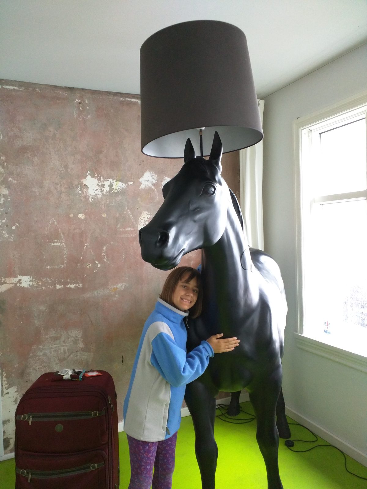 Lisa hugging a very tall horse lamp in Reykjavik