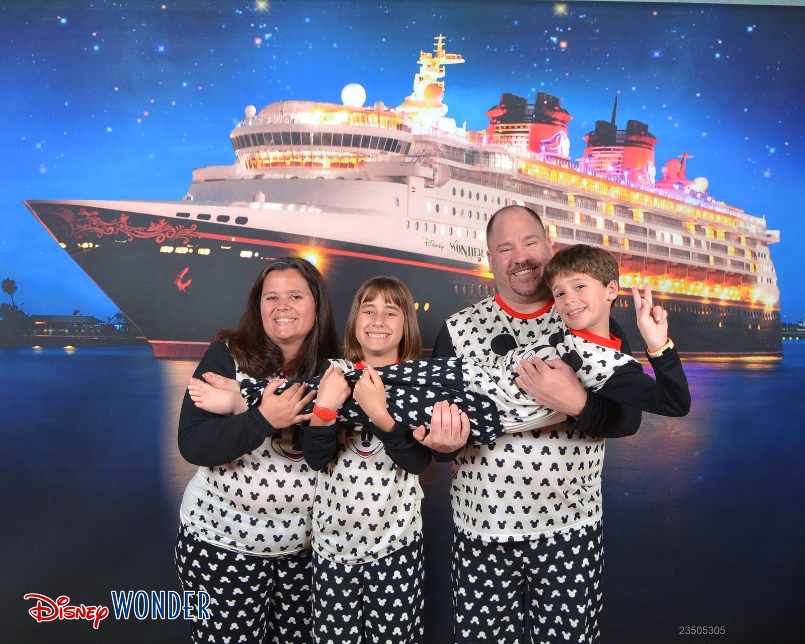 All of us in Mickey pajamas by the lit up Wonder