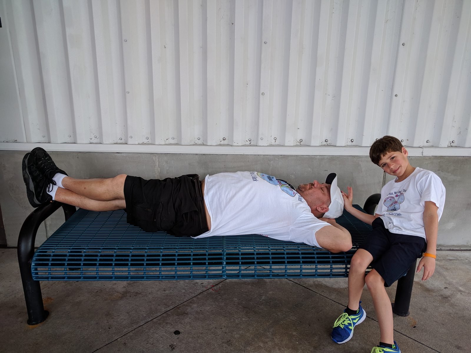Michael catching a nap on a bench while Thomas laughs