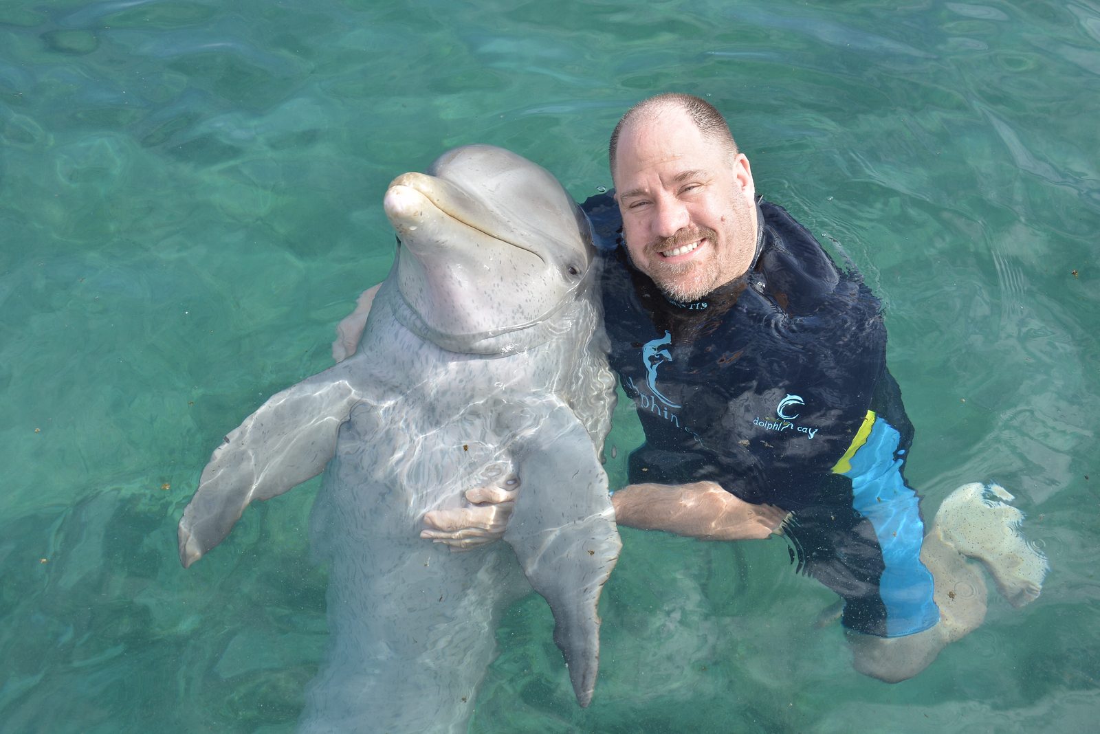 Michael and his dolphin hug at Dolphin Cay