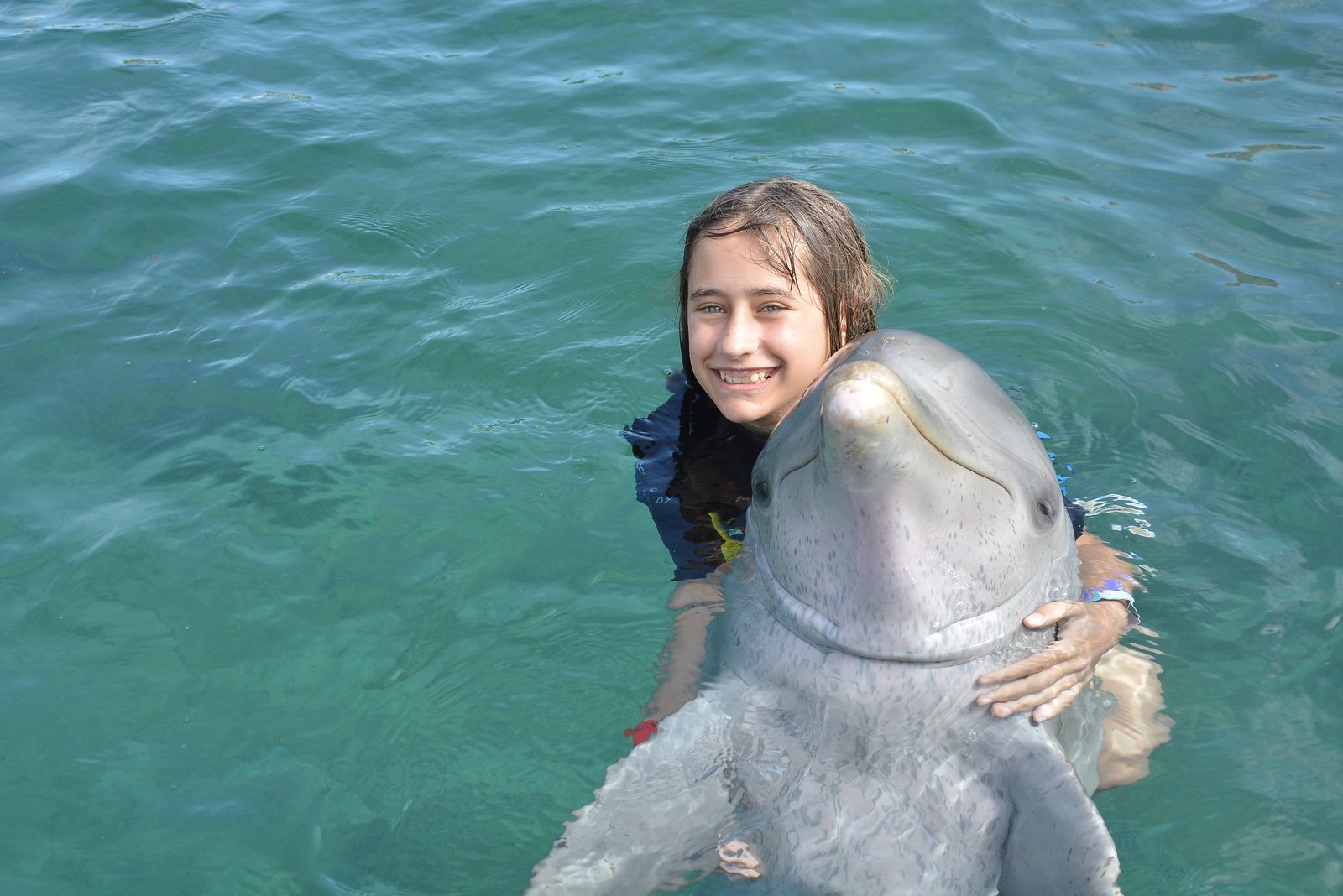 Lisa getting a dolphin hug at Dolphin Cay