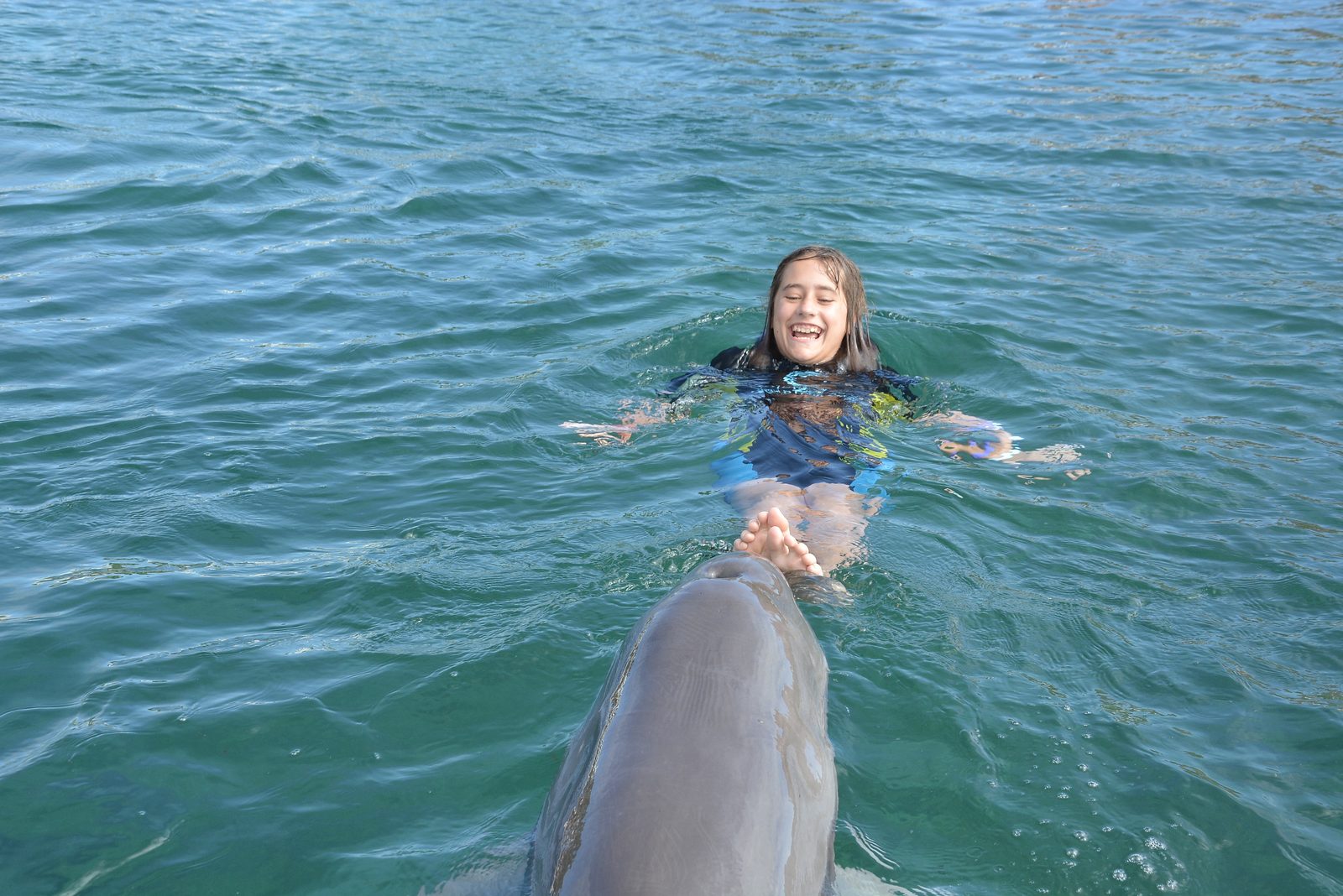 Lisa getting a foot push from the dolphin at Dolphin Cay