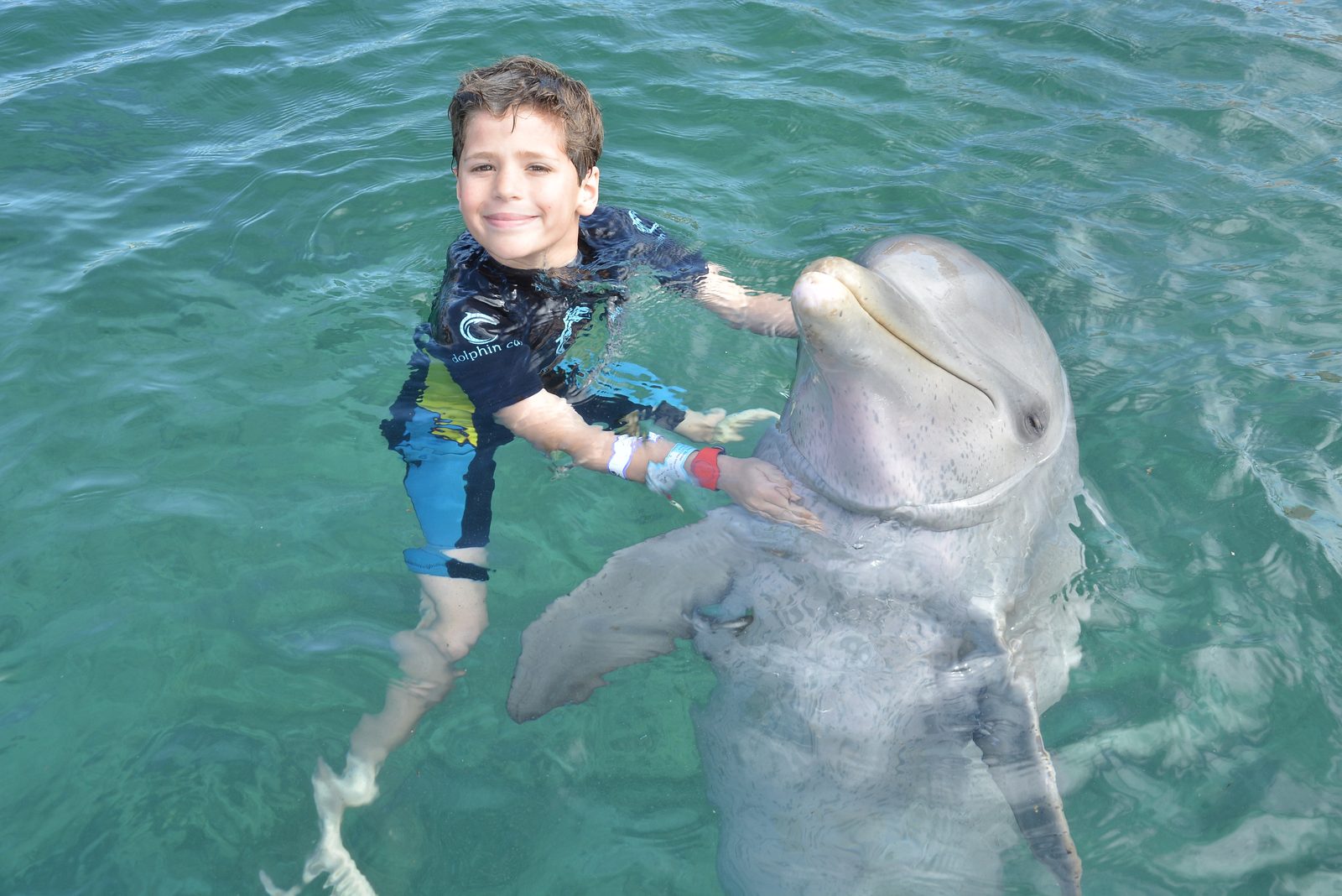 Thomas hugging the dolphin at Dolphin Cay