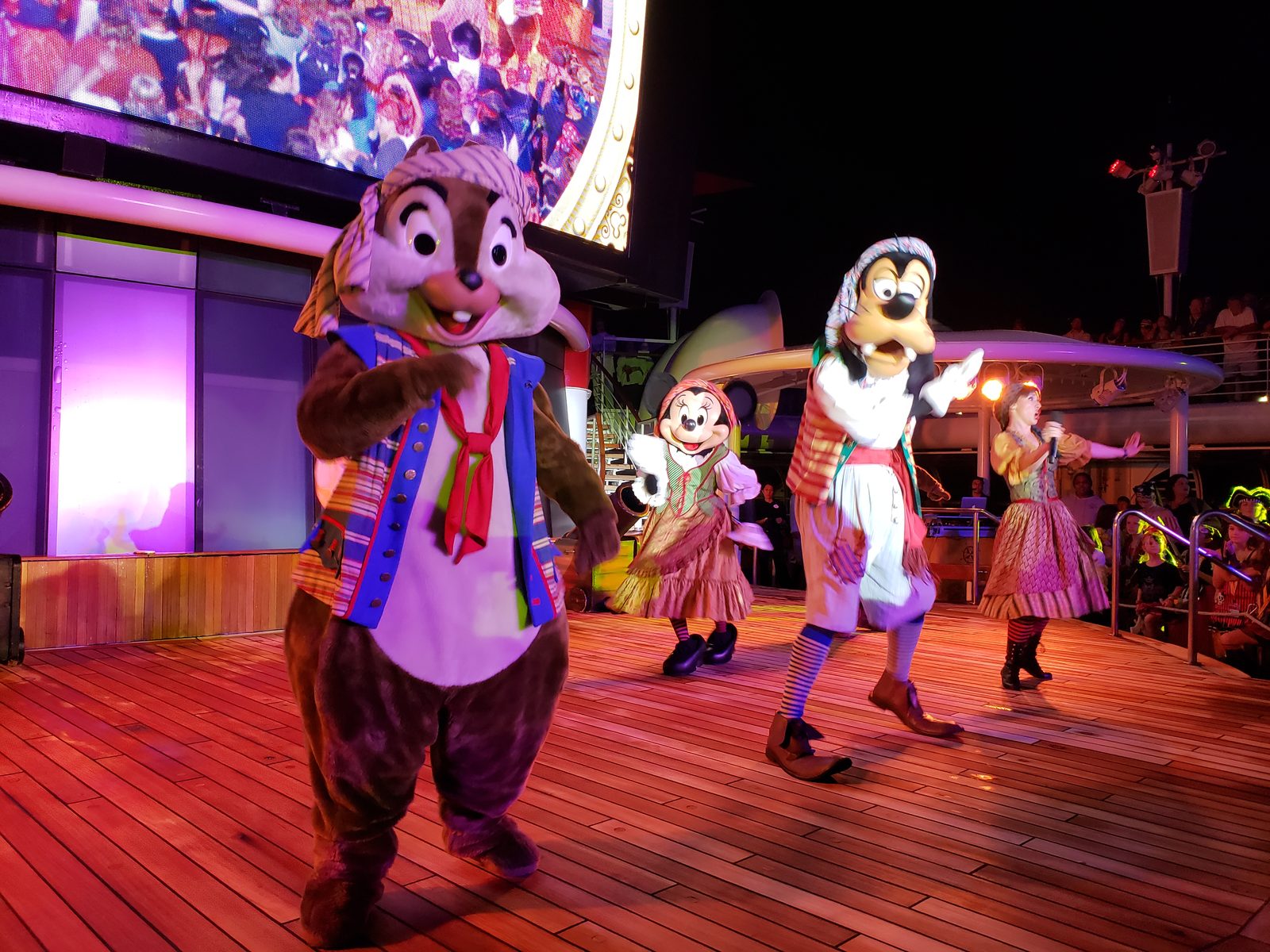 Chip, Minnie & Goofy in pirate garb dancing at the Pirates IN the Caribbean Deck Party on Pirate Night