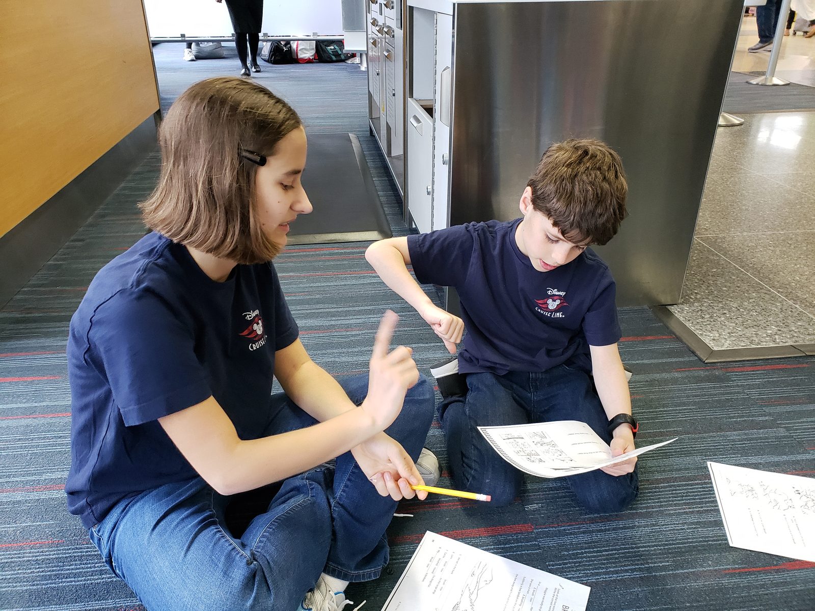 Lisa and Thomas working on travel puzzles at our gate
