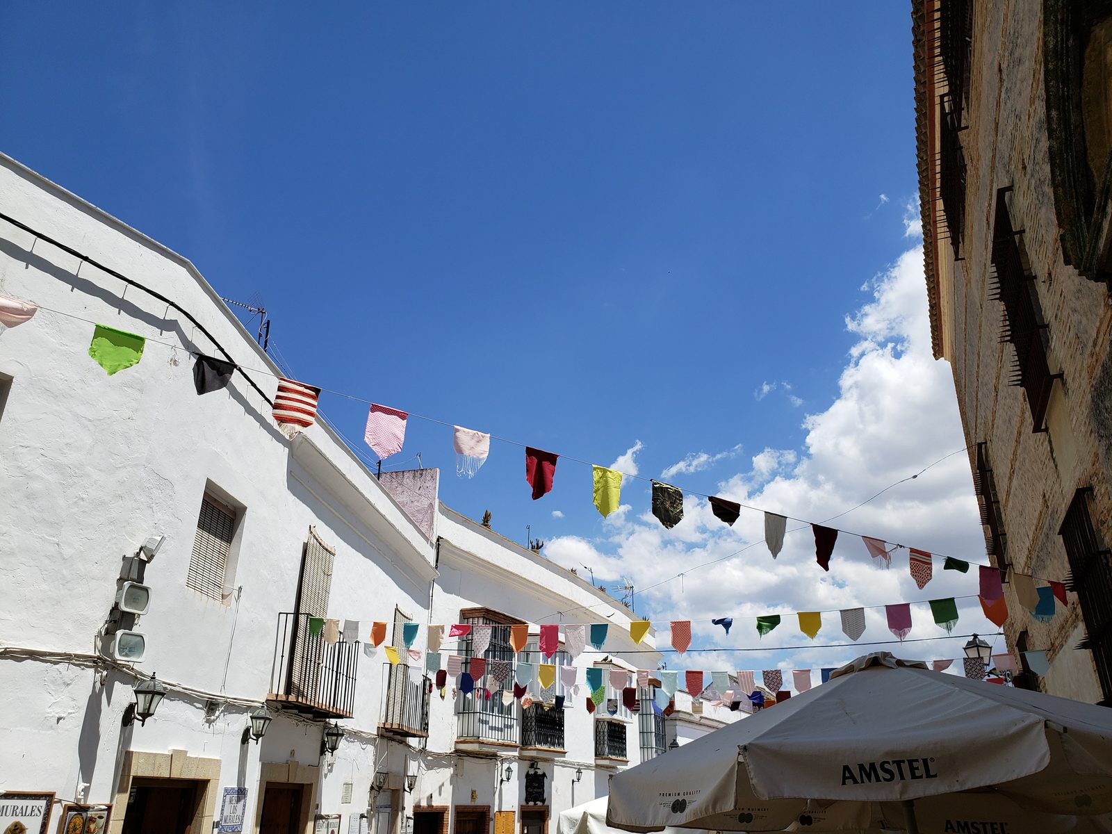 Flags strung over a white street in Arcos