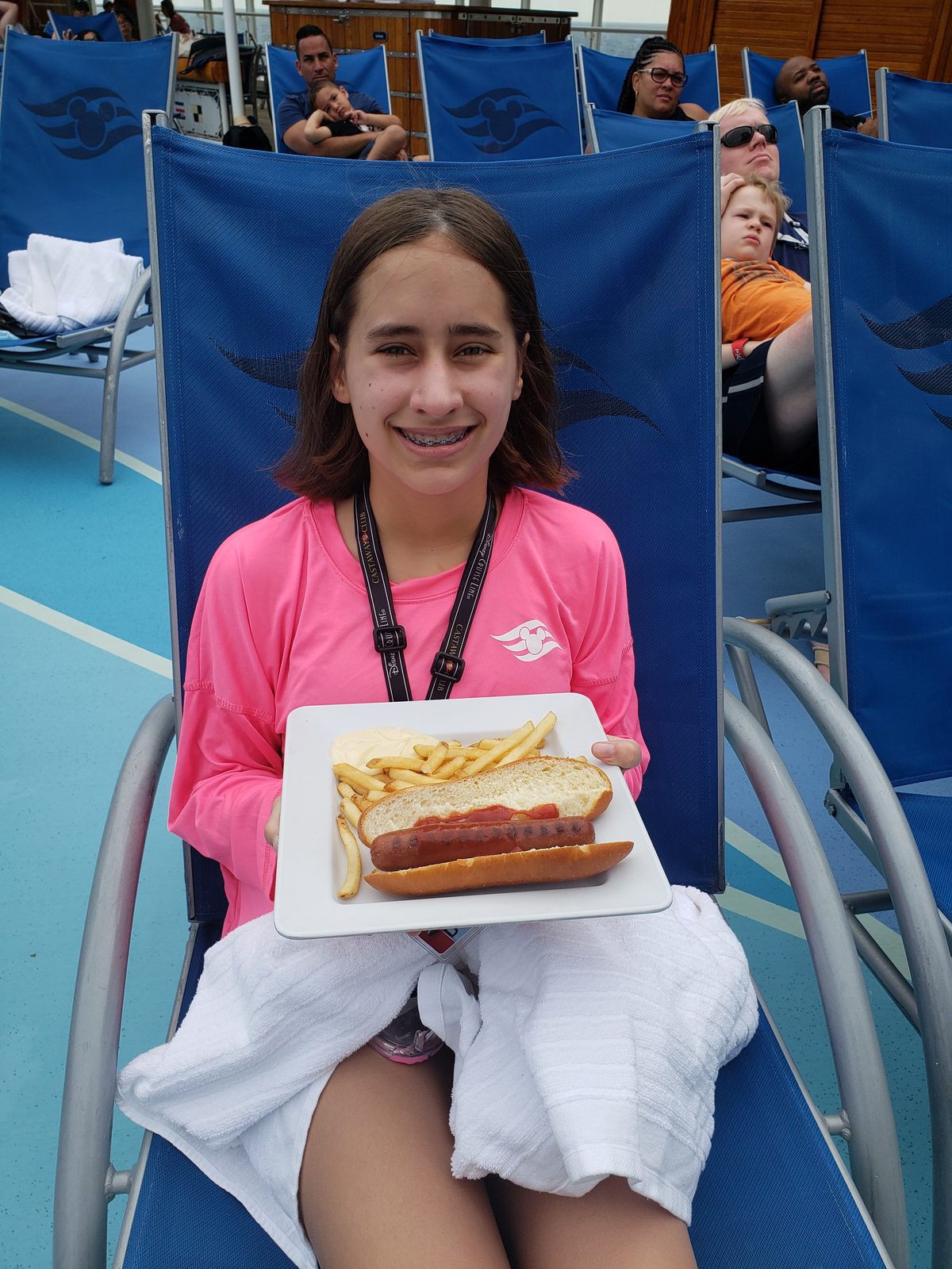 Lisa with a hot dog and fries by the pool