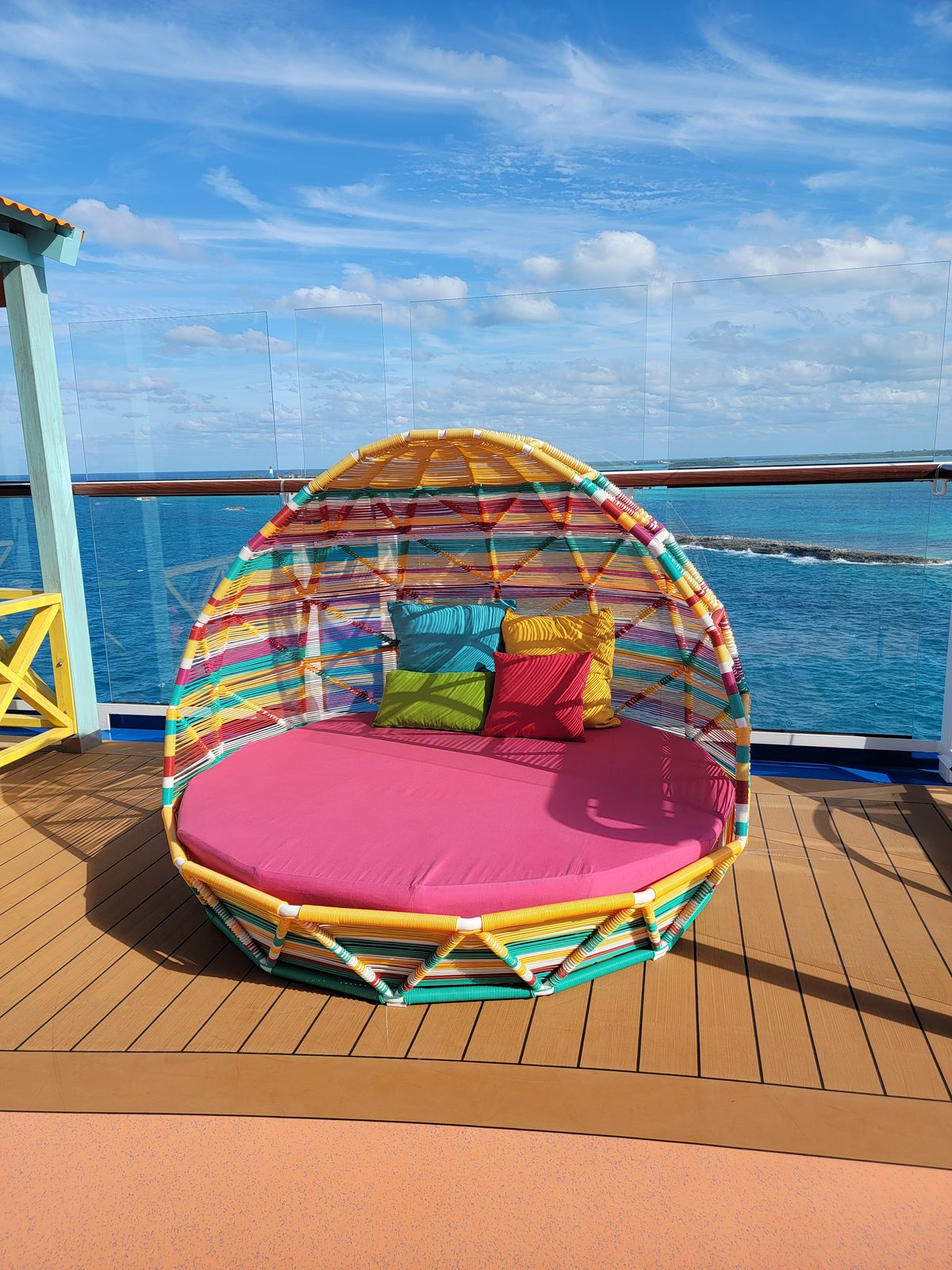 A round daybed on deck overlooking CocoCay