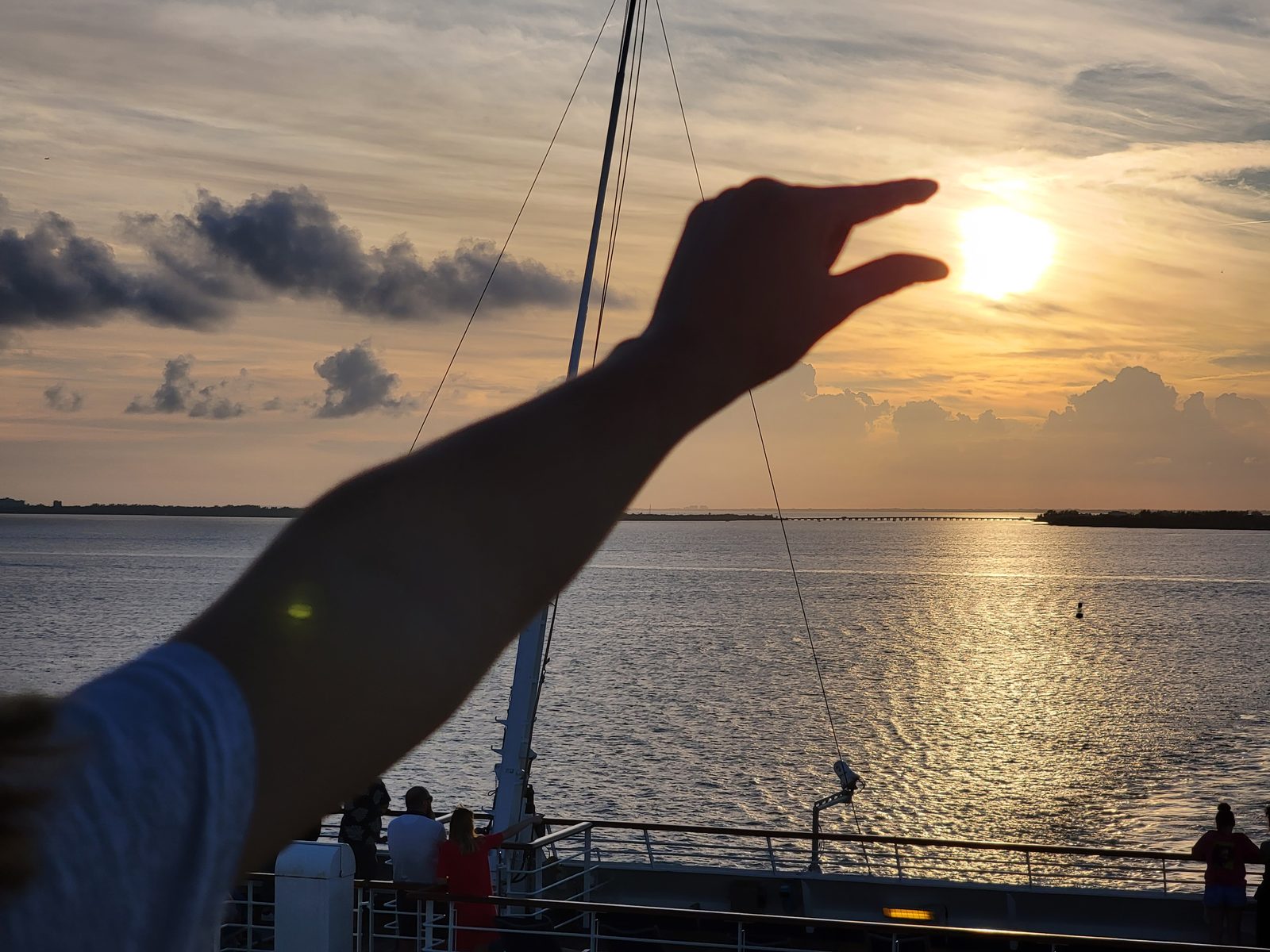 Reaching for the sunset over the water