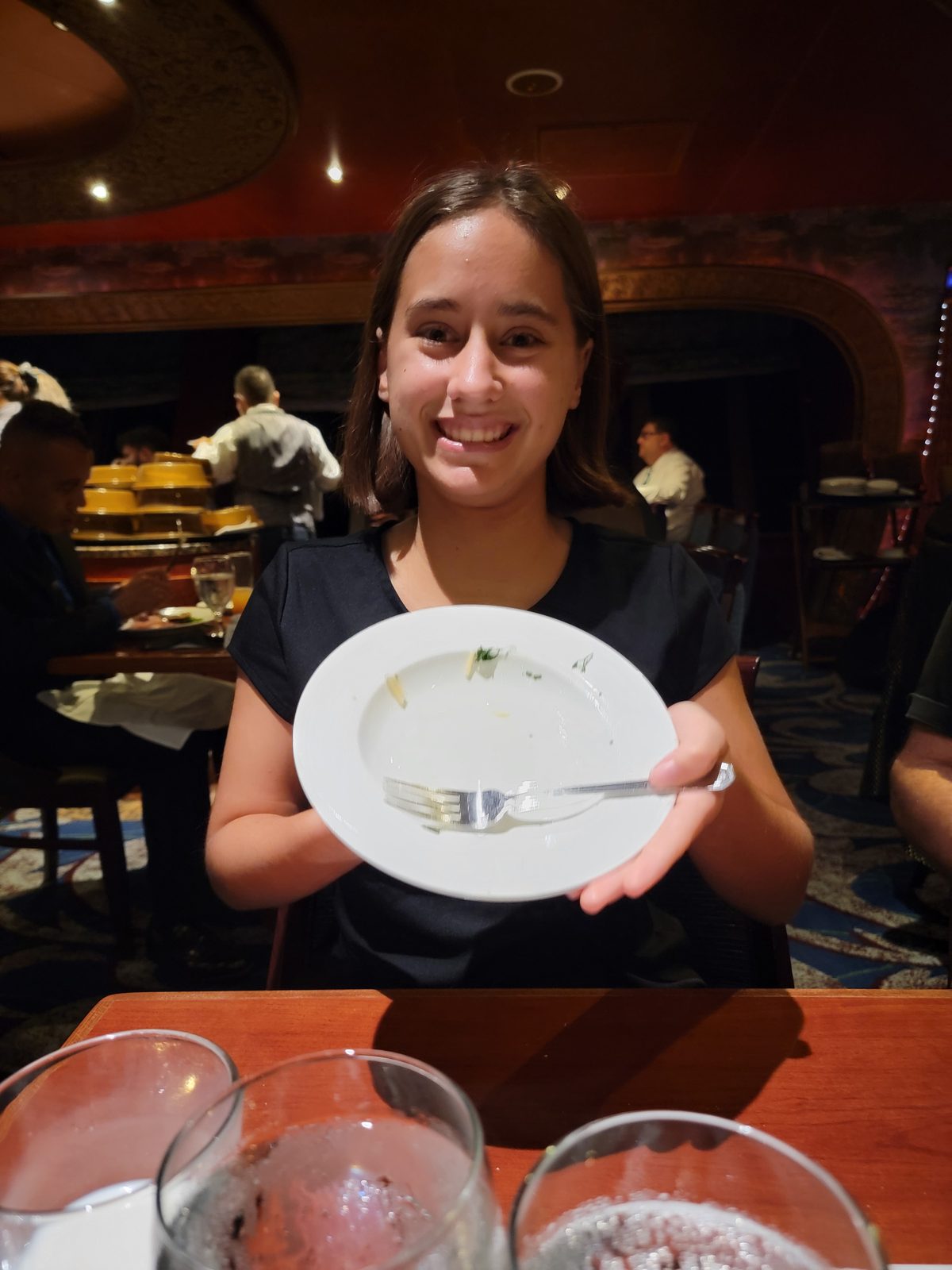 Lisa shows off her clean plate at dinner