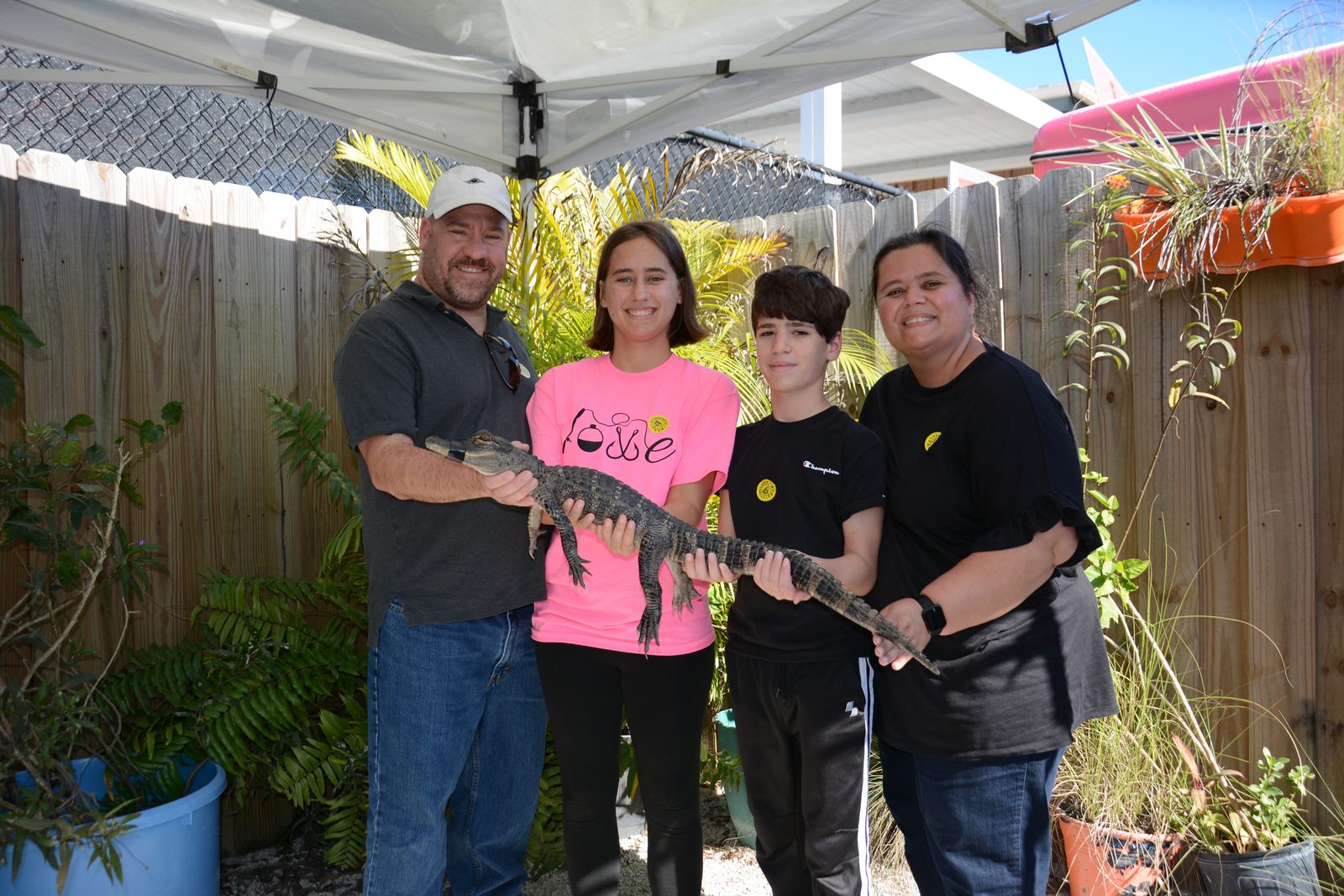 All four of us holding a small alligator