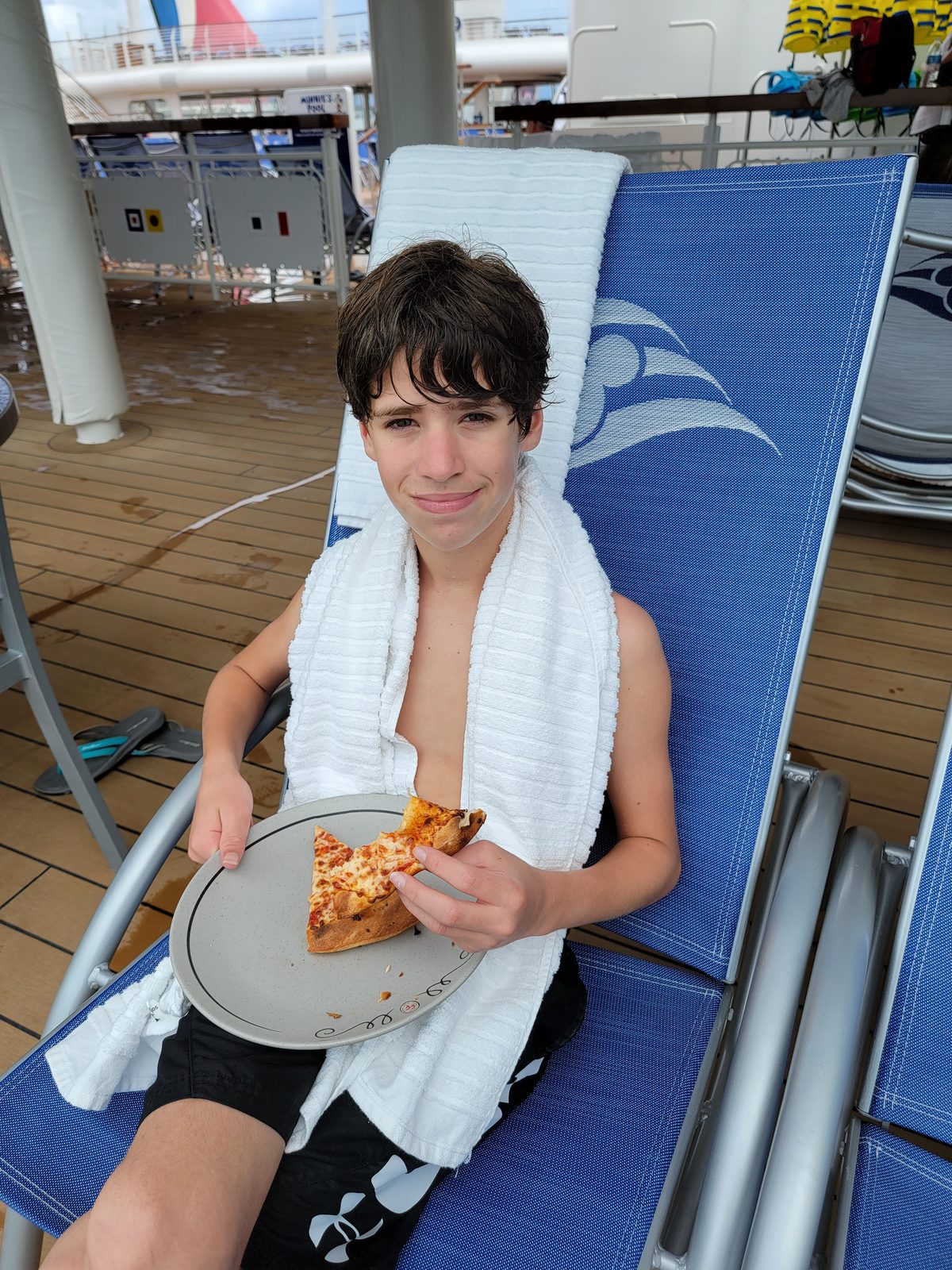 Thomas with pizza on deck in Nassau