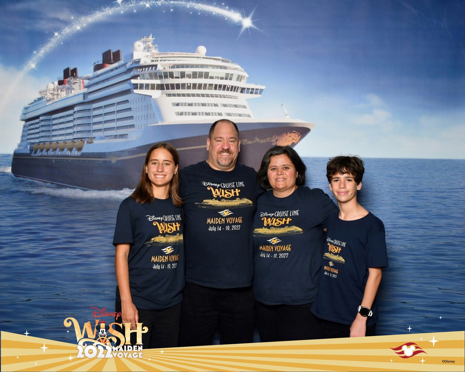 The four of us in front of the Disney Wish backdrop