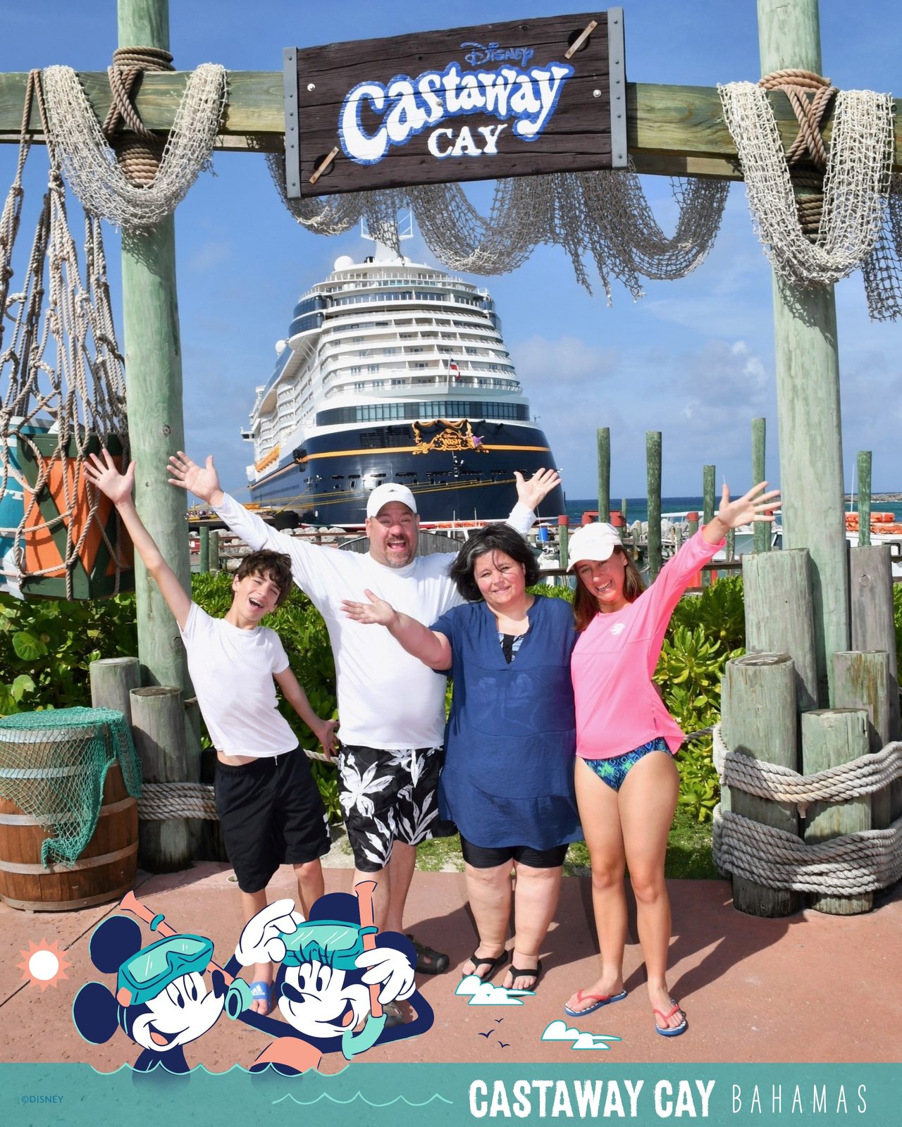 The four of us cheering under the Castaway Cay sign