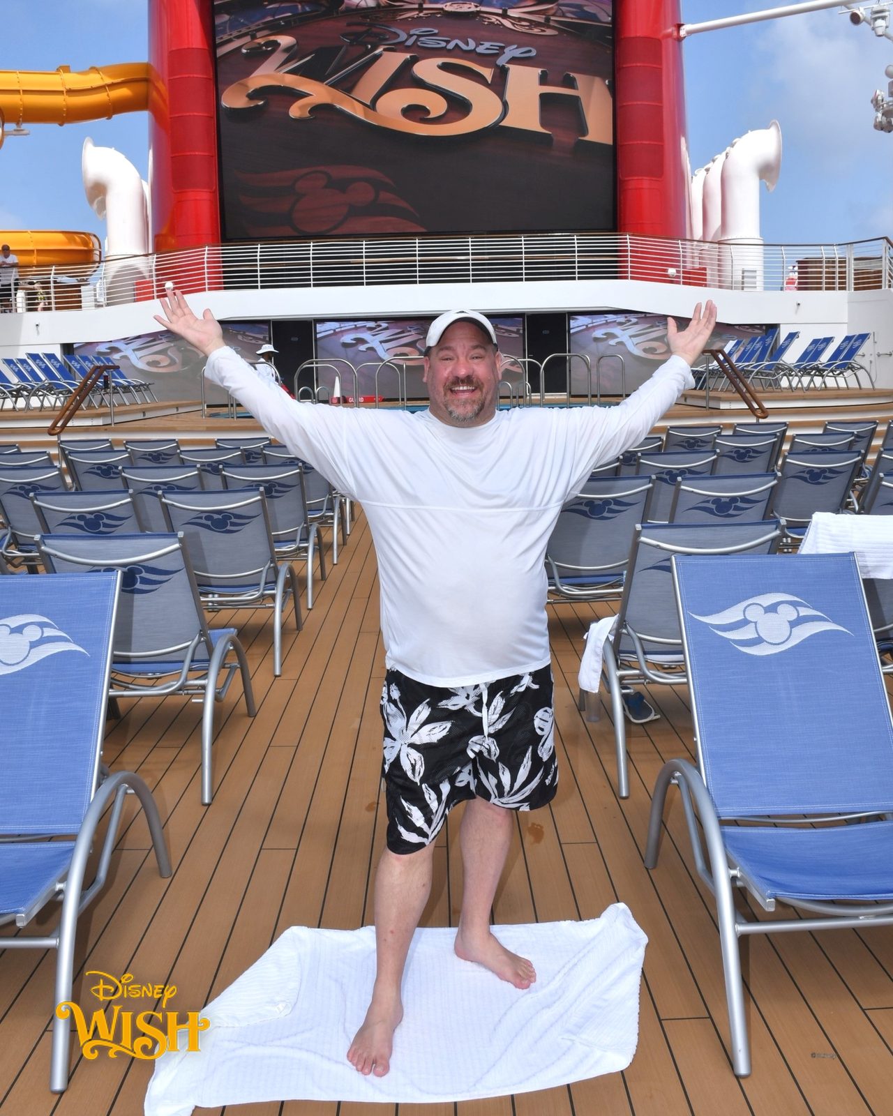 Michael on the pool deck of the Wish with arms wide