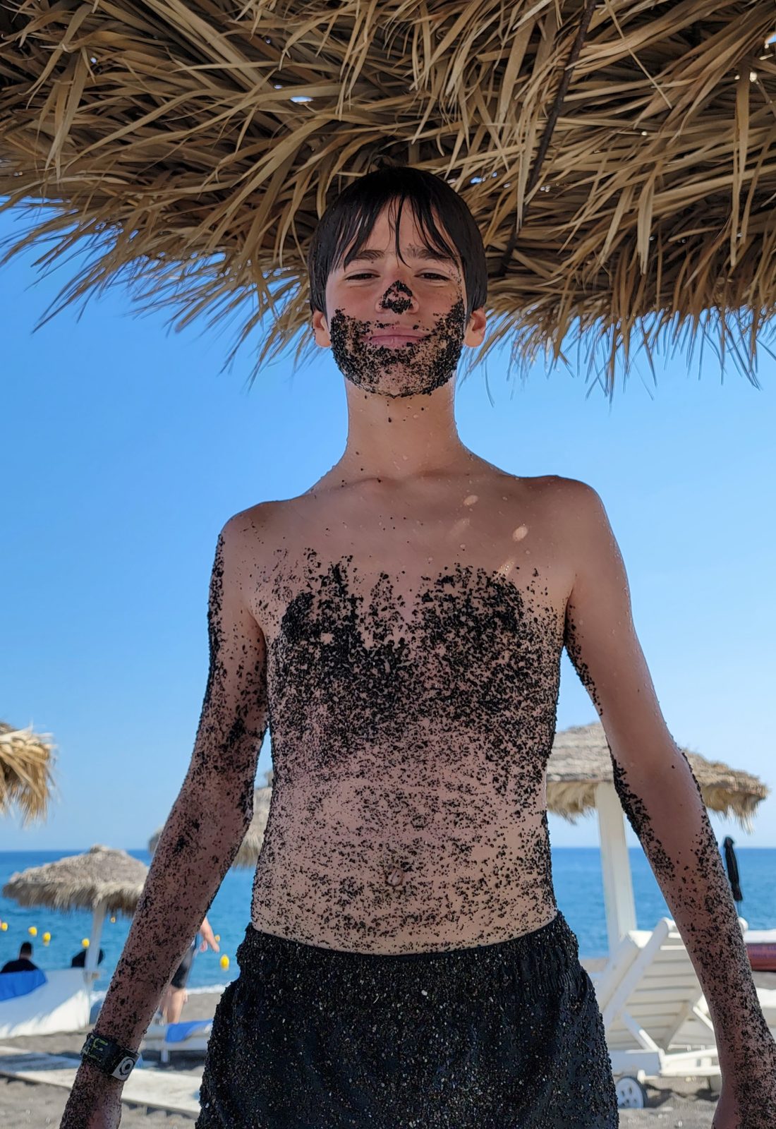 Thomas covered head to toe in black sand
