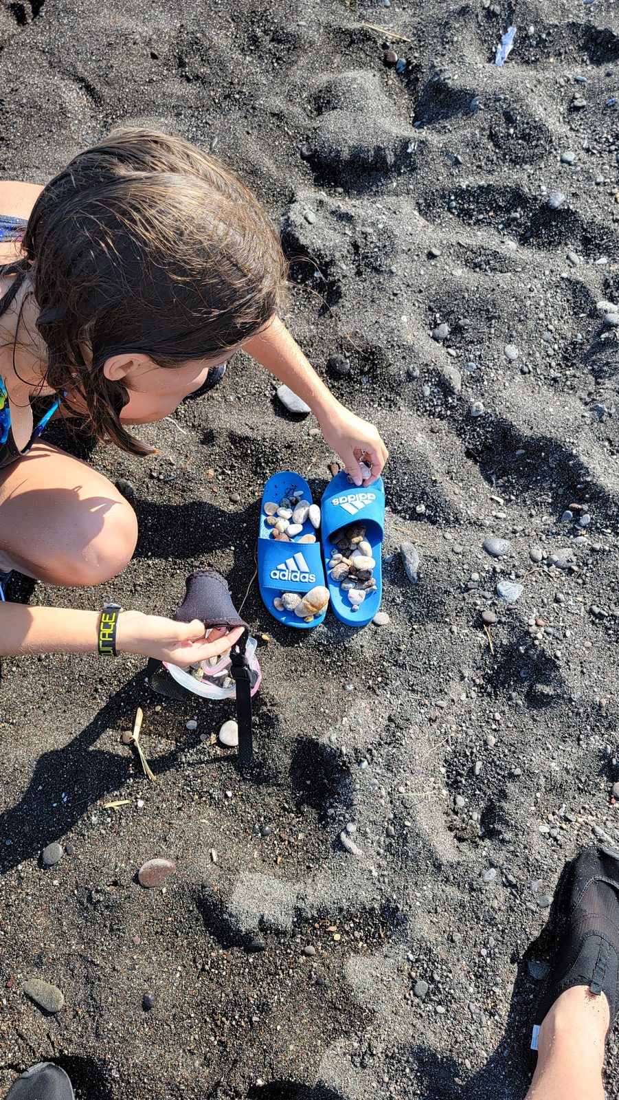 Collecting pebbles on the black sand