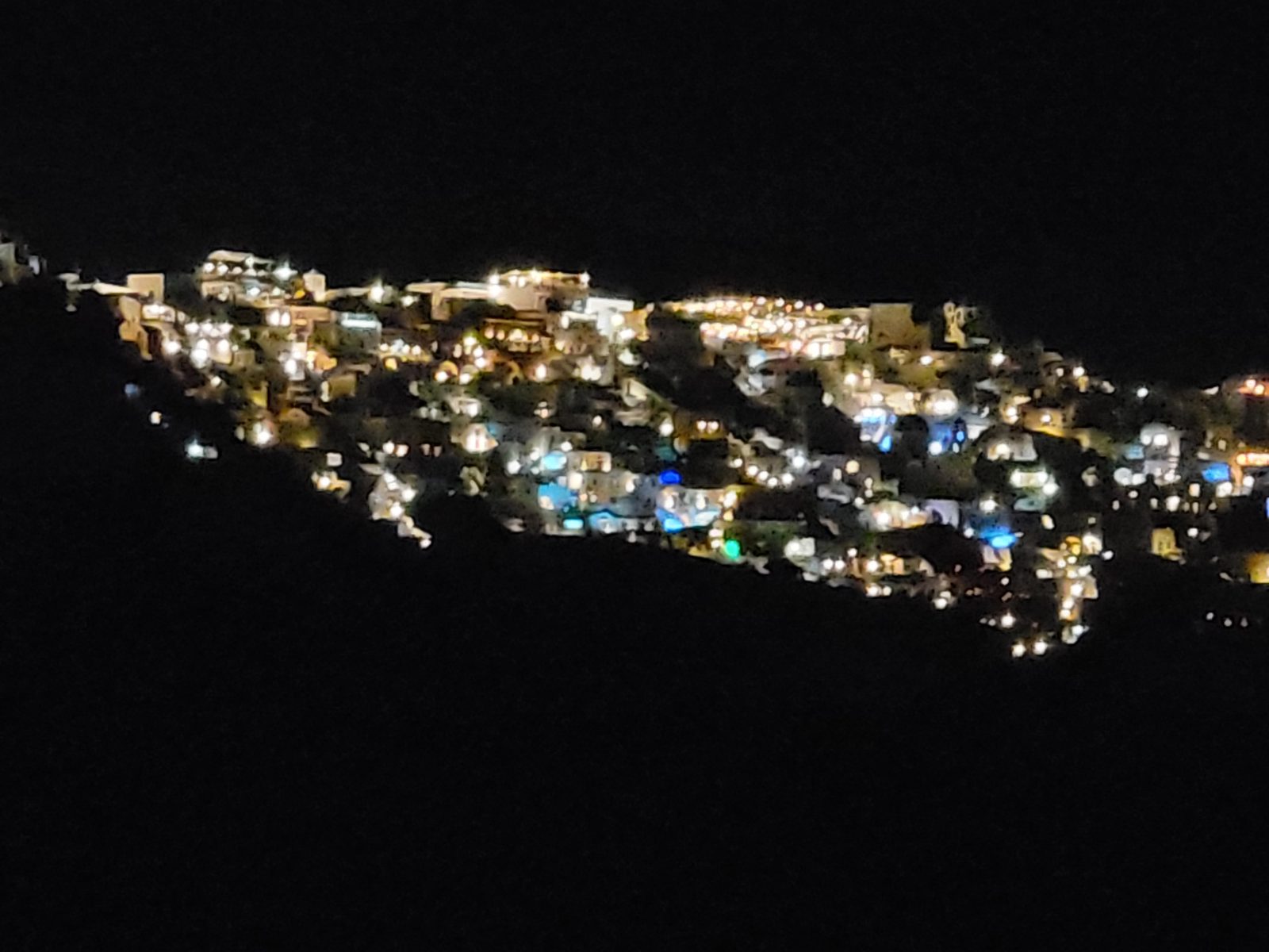 Santorini lit up along the cliffside at night