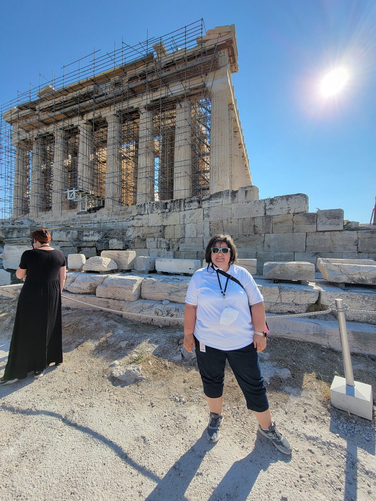 Kathy standing before a large columned temple under scaffolding
