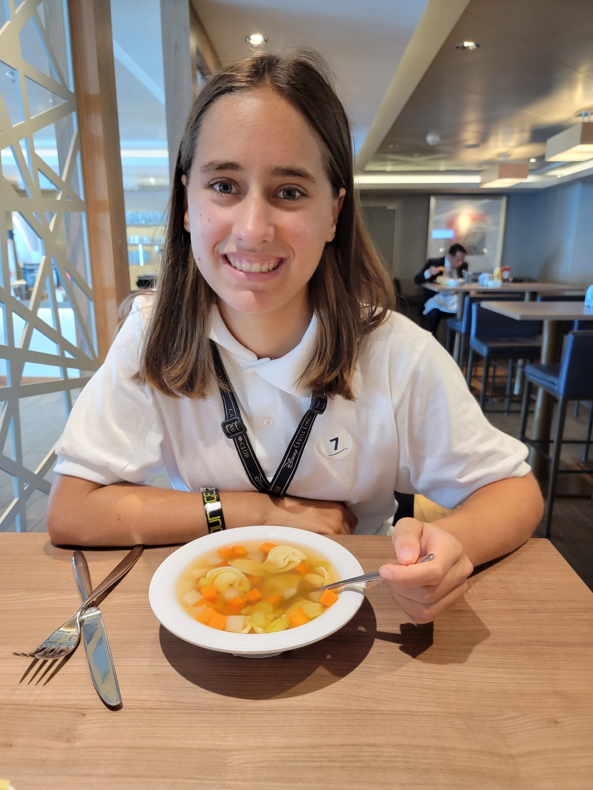 Lisa eating soup at a table in a ship restaurant