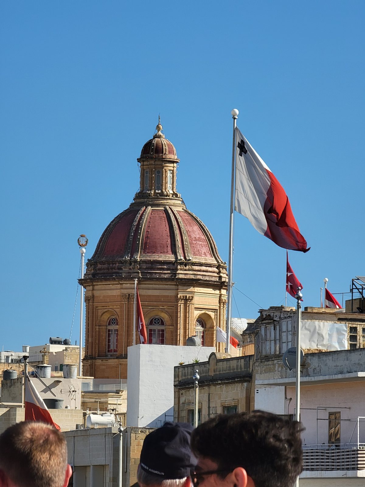 A domed church and the Maltese flag in Birgu