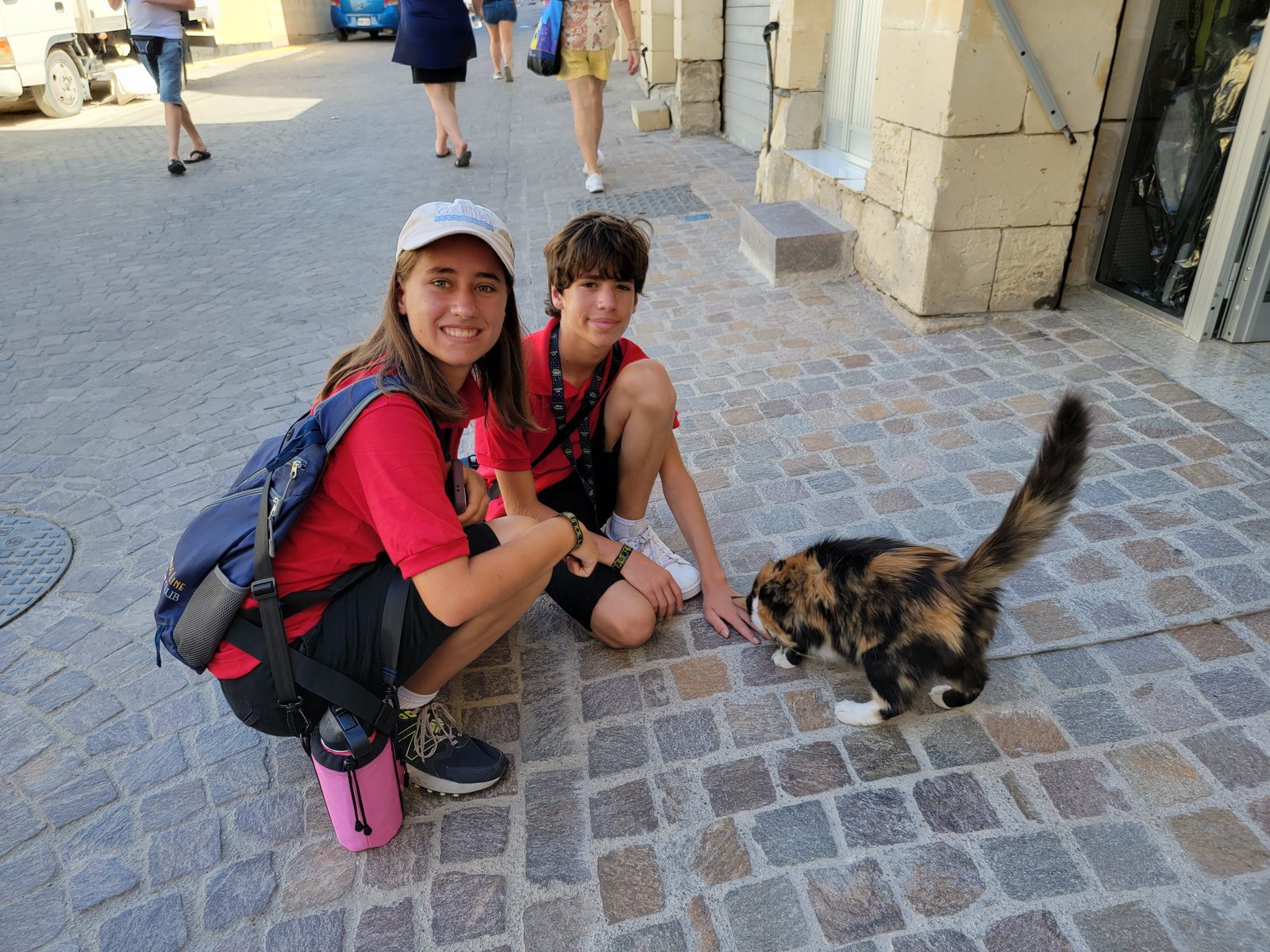 Thomas and Lisa petting a stray cat in Marsaxlokk