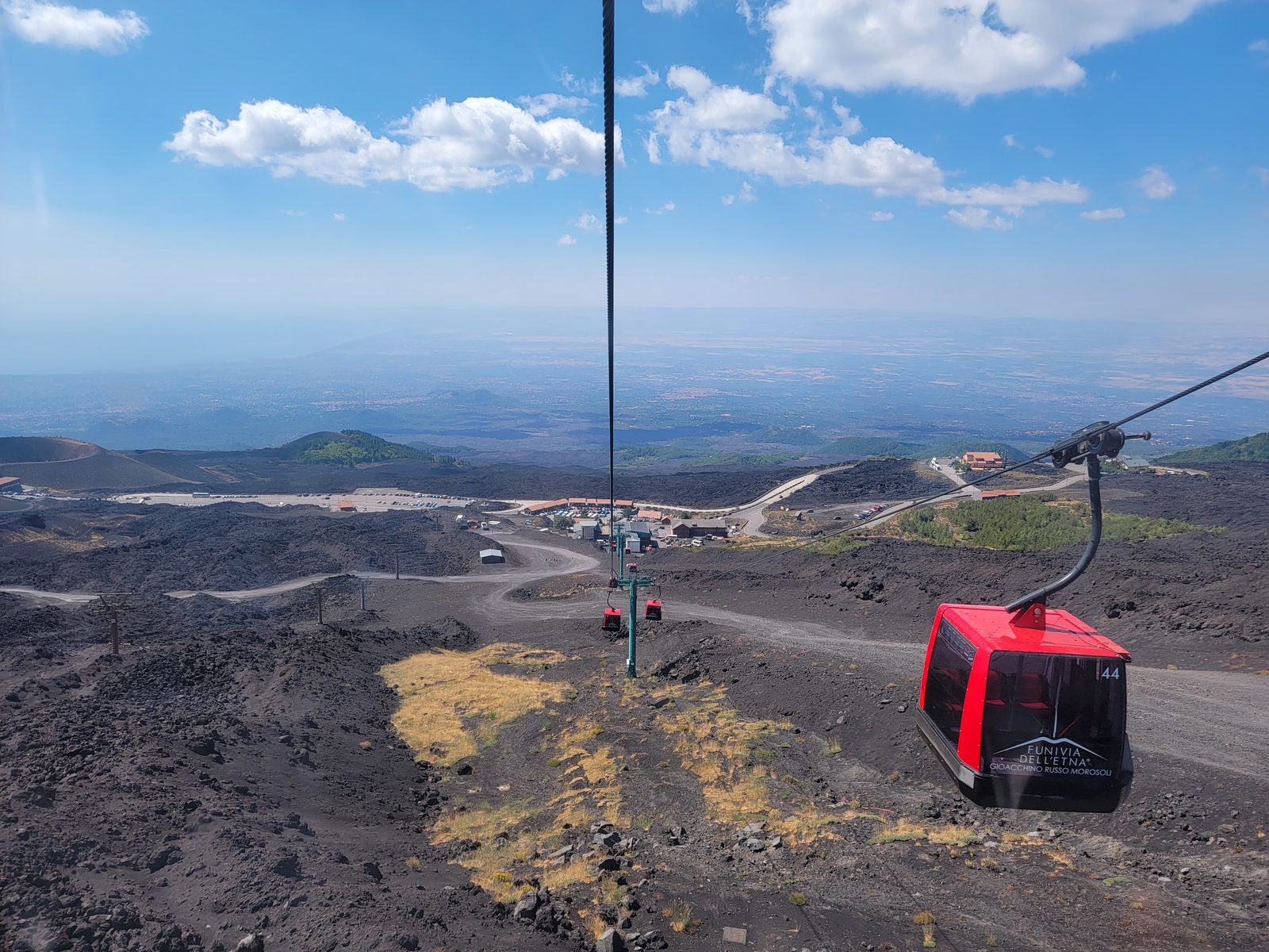 The cable car climbs Etna's black lava slopes