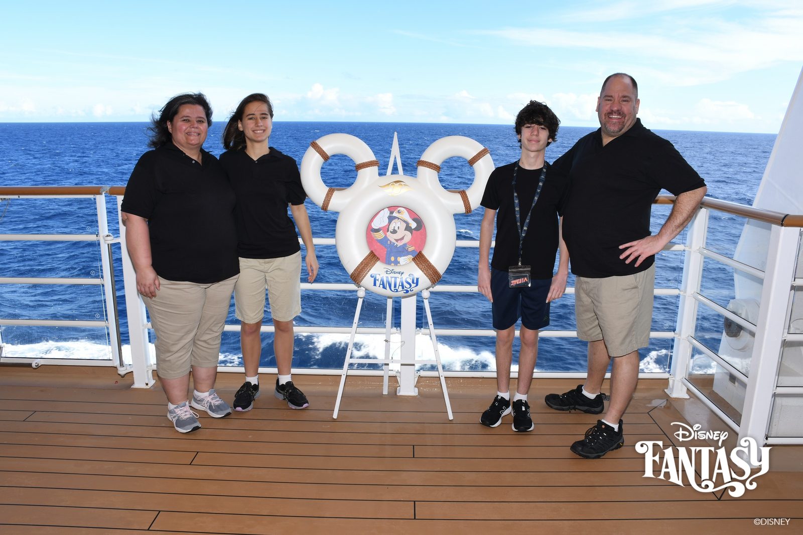 Family portrait at the rail by the Mickey life ring