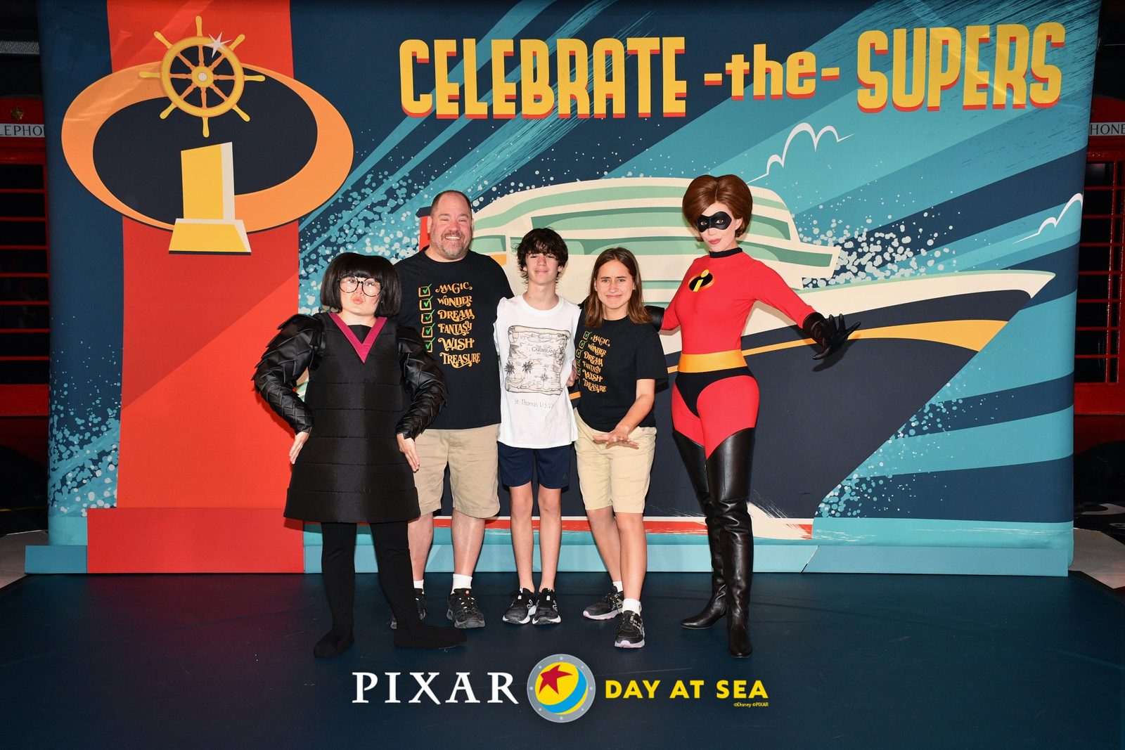Edna Mode, Michael, Thomas, Lisa and Mrs. Incredible at the Celebrate the Supers backdrop on Pixar Day at Sea
