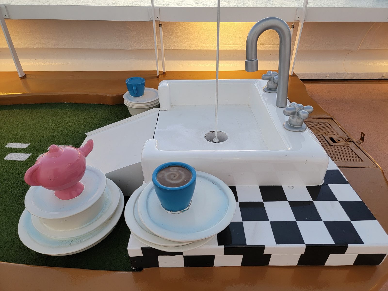 A giant sink and teacups on the ship's mini golf course
